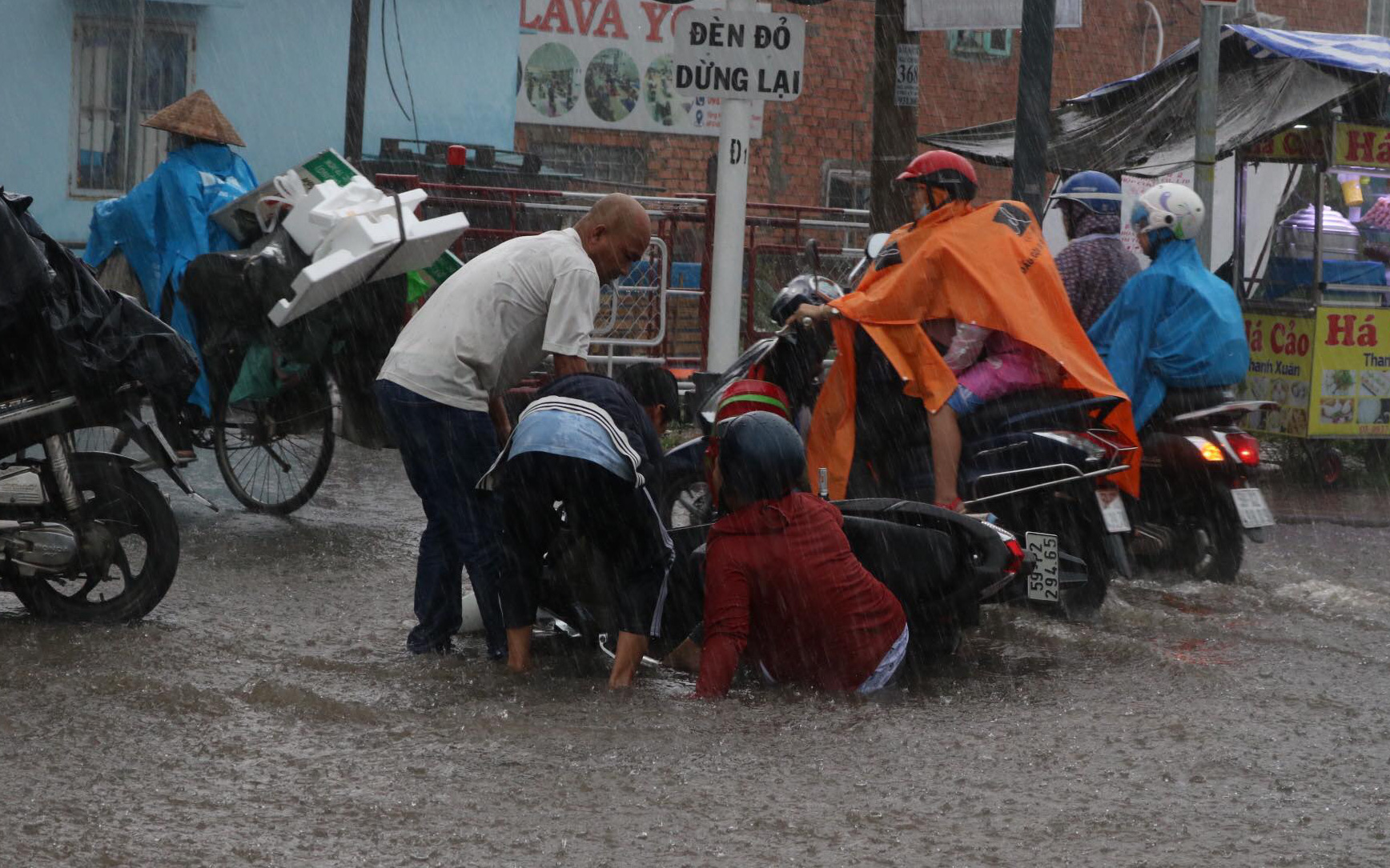 TP.HCM mưa gió mù mịt 2 tiếng: đường ngập khắp nơi, cây đổ, xe ngã...