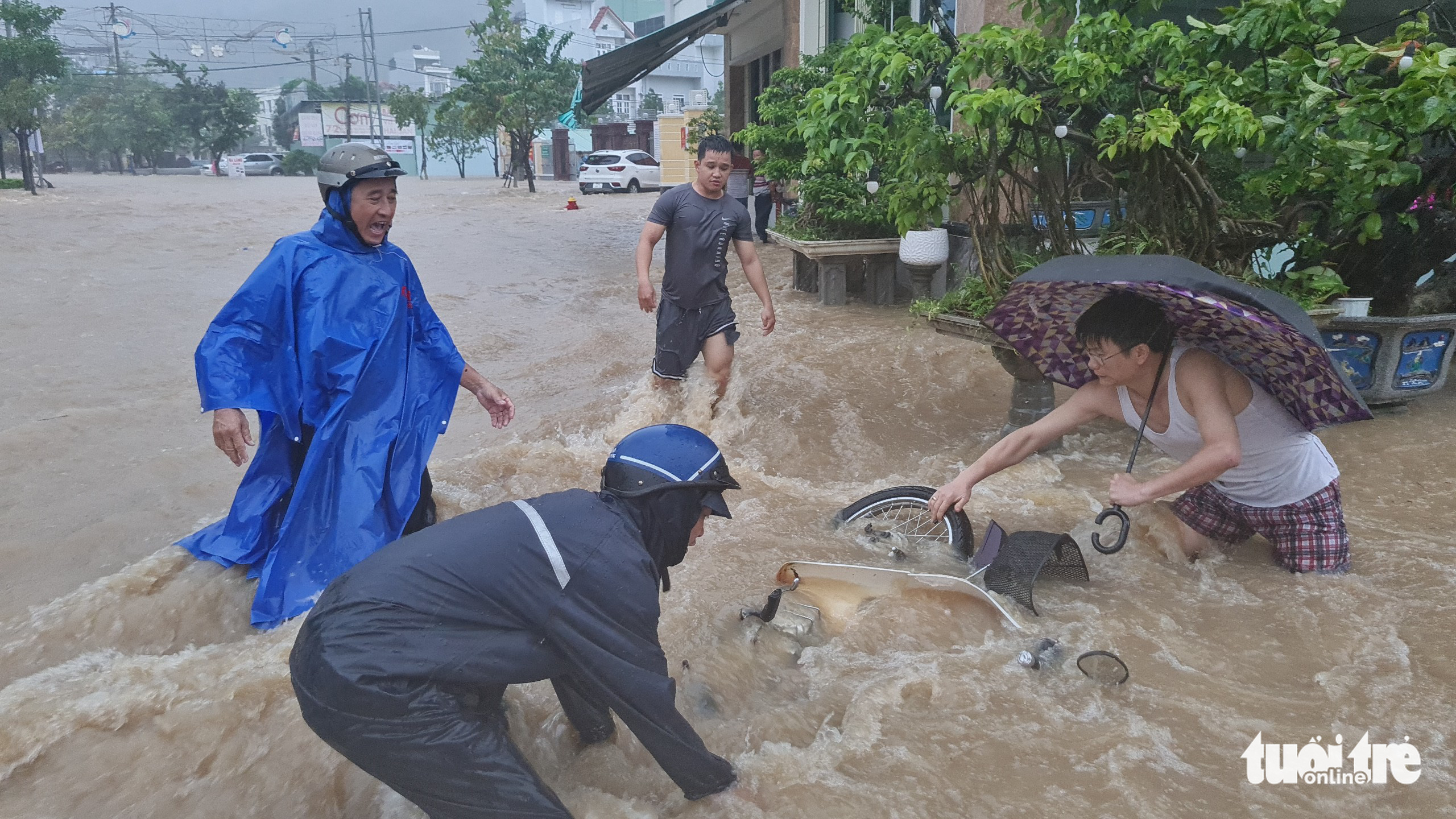 Mưa lớn kéo dài tại Quy Nhơn, xe máy và người đi đường bị nước cuốn - Ảnh 1.