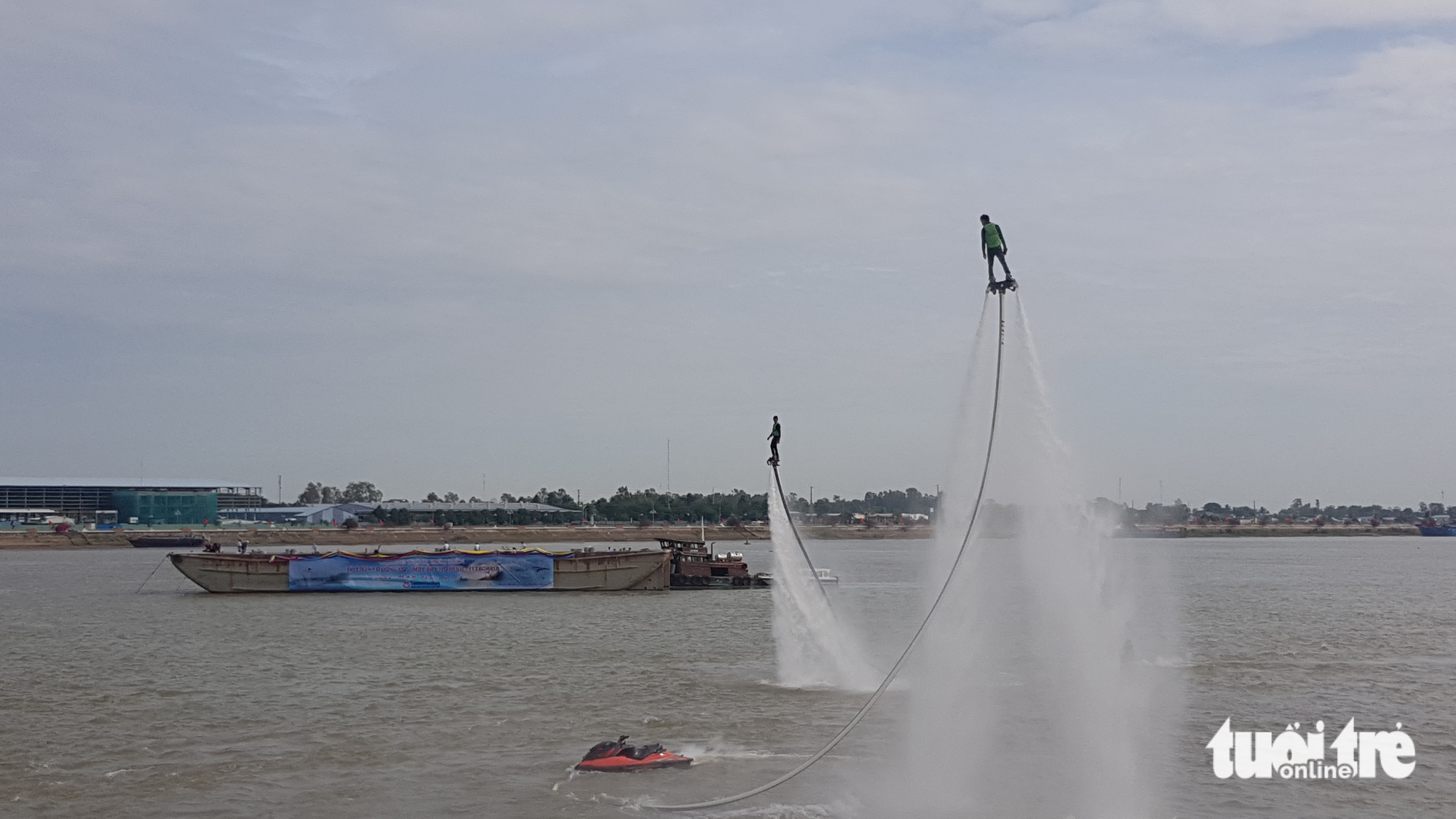 Người dân chen kín bờ kè sông Tiền xem flyboard, dù lượn - Ảnh 1. Người dân chen kín bờ kè sông Tiền xem flyboard, dù lượn - Ảnh 1.