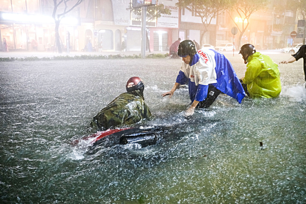 Tháng 10-2022 TP Đà Nẵng xảy ra mưa lớn dồn dập làm nhiều nơi ngập lụt. Trong ảnh: người dân dắt xe máy đi trong nước lụt trên đường Nguyễn Văn Linh ngày 14-10-2022 - Ảnh: TẤN LỰC