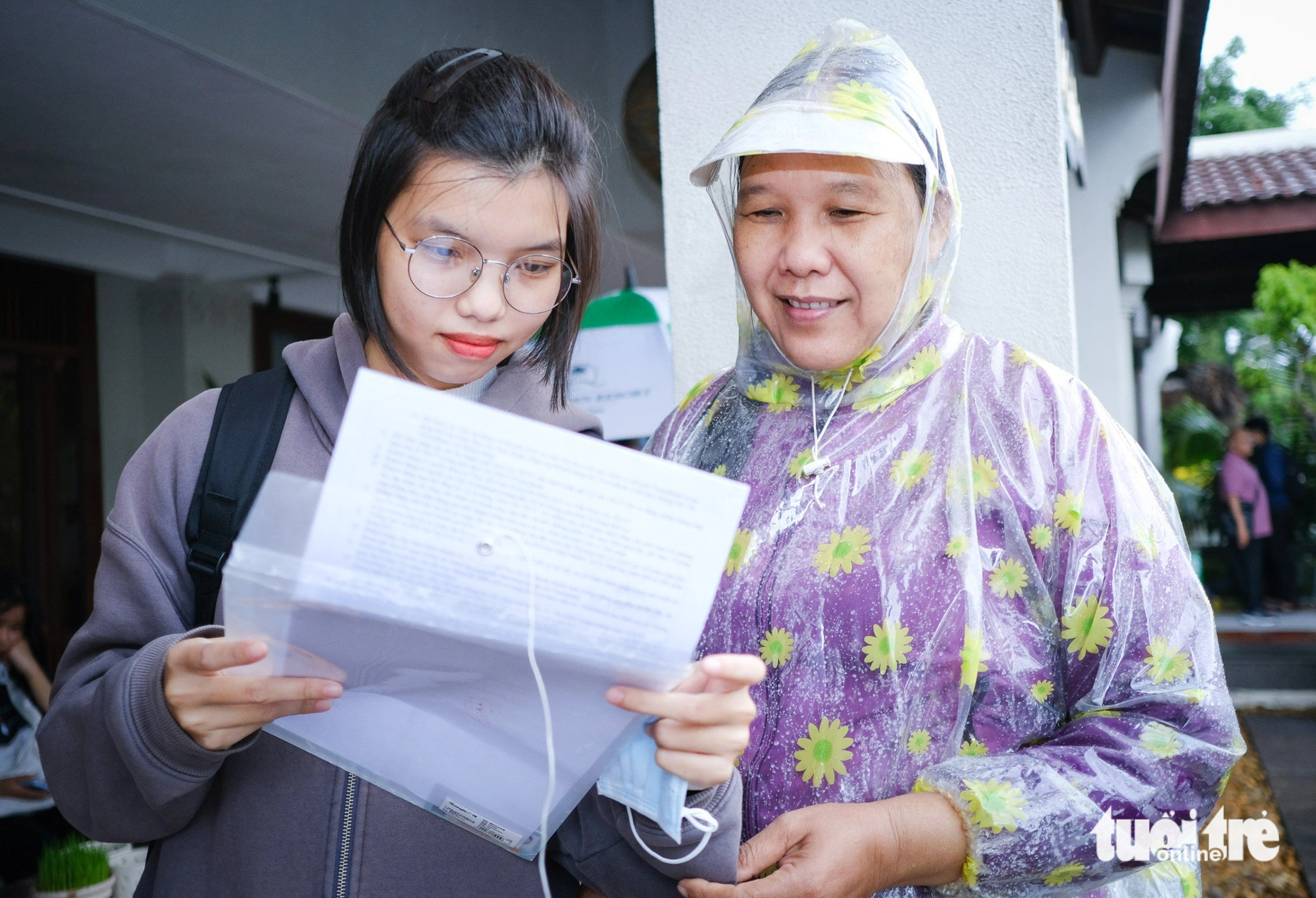 Tân sinh viên Nguyễn Doãn Hà Ngân, Núi Thành, Quảng Nam, cùng mẹ đội mưa tới nhận học bổng Tiếp sức đến trường - Ảnh: TẤN LỰC