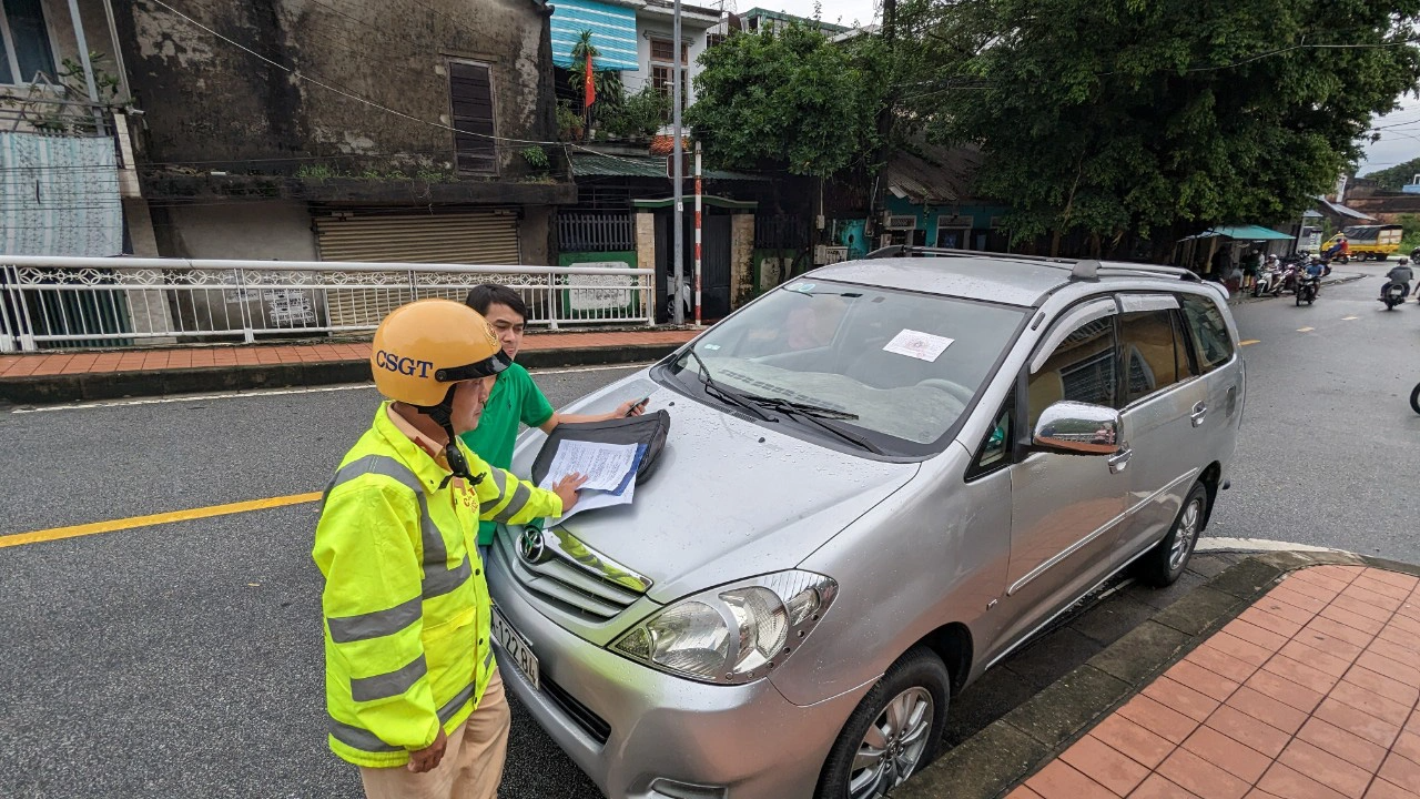 Chủ xe đậu trên cầu Đông Ba (TP Huế) để tránh lũ thì bị lực lượng cảnh sát xử phạt chiều 18-10 - Ảnh: NHẬT LINH