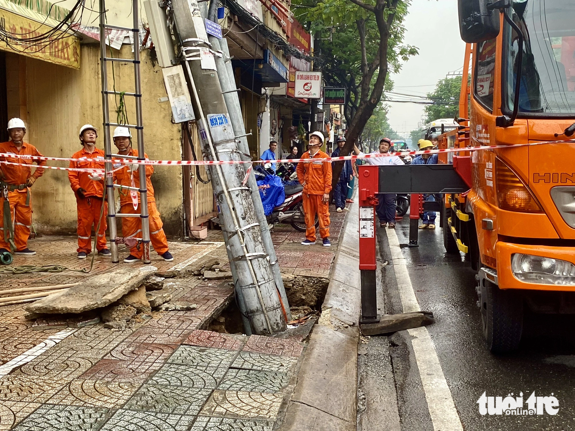 Nguyên nhân được xác định do cống thoát nước bị vỡ cuốn trôi phần đất chân trụ điện - Ảnh: TIẾN QUỐC