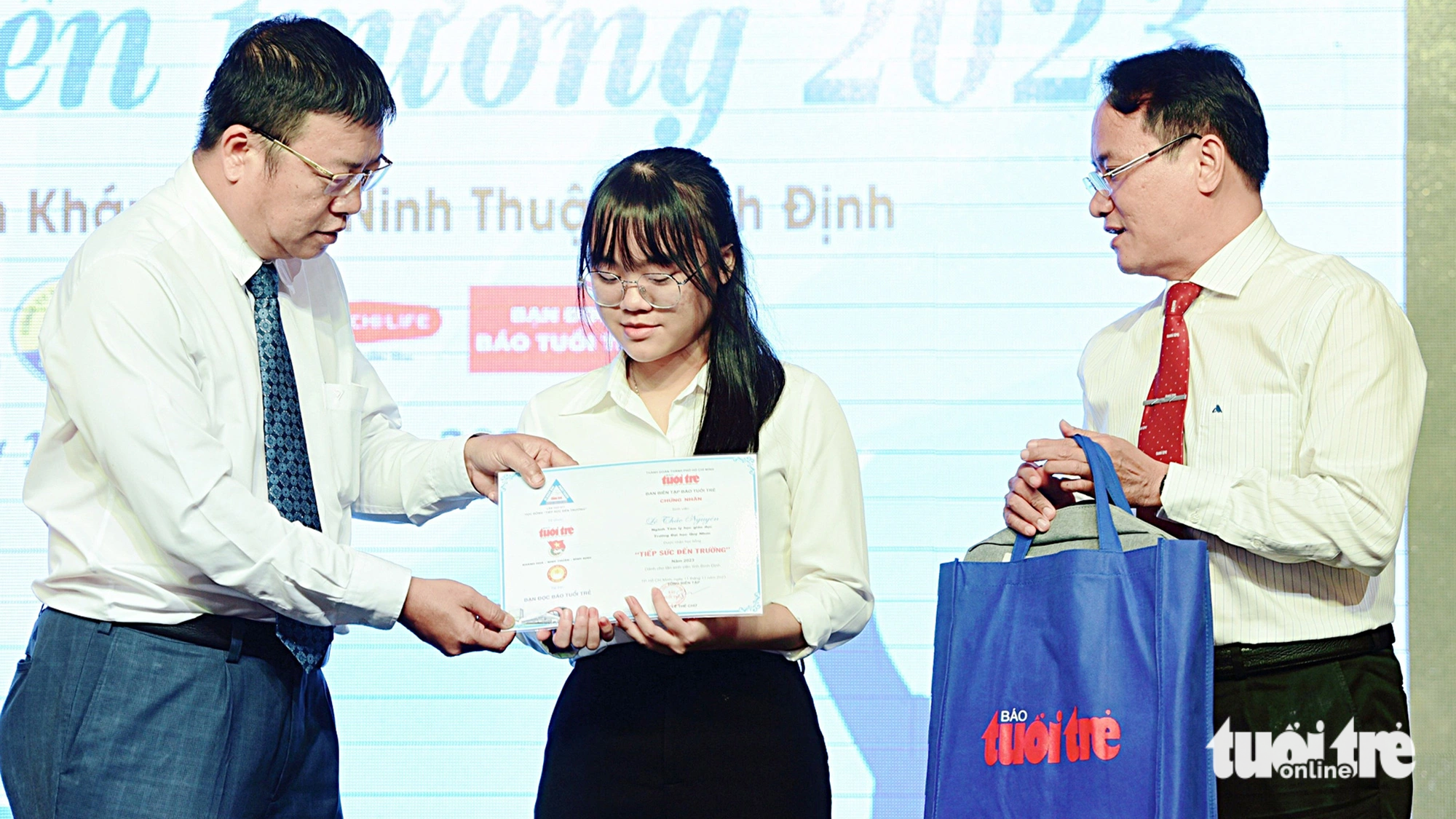 Vo Hoan Hai, director of Khanh Hoa Education and Training Department (left) and Nguyen Hoang Nguyen (right), deputy editor-in-chief of Tuoi Tre newspaper, presented scholarships to new students - Photo: Duyen Phan