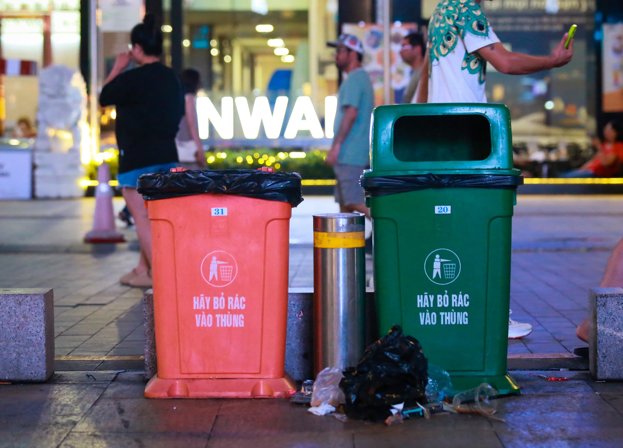 The dustbins located on Nguyen Hue Walking Street are empty but people still peacefully throw out trash outside!  - Photo: Phuong Quanyen