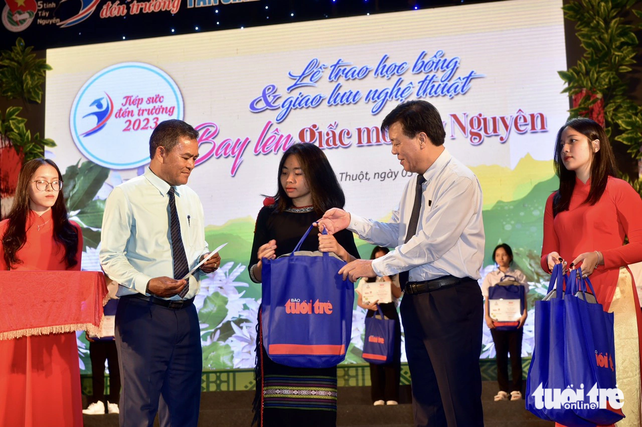 Trao học bổng cho em H'Thư Ajun - tân sinh viên Trường ĐH Tây Nguyên - Ảnh: T.T.D. Ông Y Biêr Niê - Phó bí thư Tỉnh ủy Đắk Lắk (trái) và ông Ngô Văn Đông - Chủ tịch Quỹ “Đồng hành nhà nông”, Tổng giám đốc Công ty cổ phần phân bón Bình Điền - Trao học bổng cho em H'Thư Ajun, tân sinh viên Trường ĐH Tây Nguyên, một trong những bạn trẻ vượt qua định kiến phải ở nhà "bắt chồng" để theo đuổi ước mơ "bắt con chữ" - Ảnh: T.T.D.