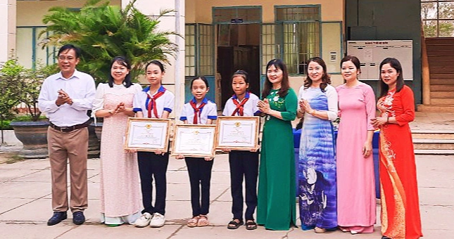Mr. Pham Anh Tan (right cover) – member of the Standing Committee, head of the Propaganda Department of Son Hoa District Party Committee – presented certificates of merit to 3 female students at Primary School No. 1 in Quảng Sơn City who discovered and rescued a Newborn baby girl abandoned – Photo: AT