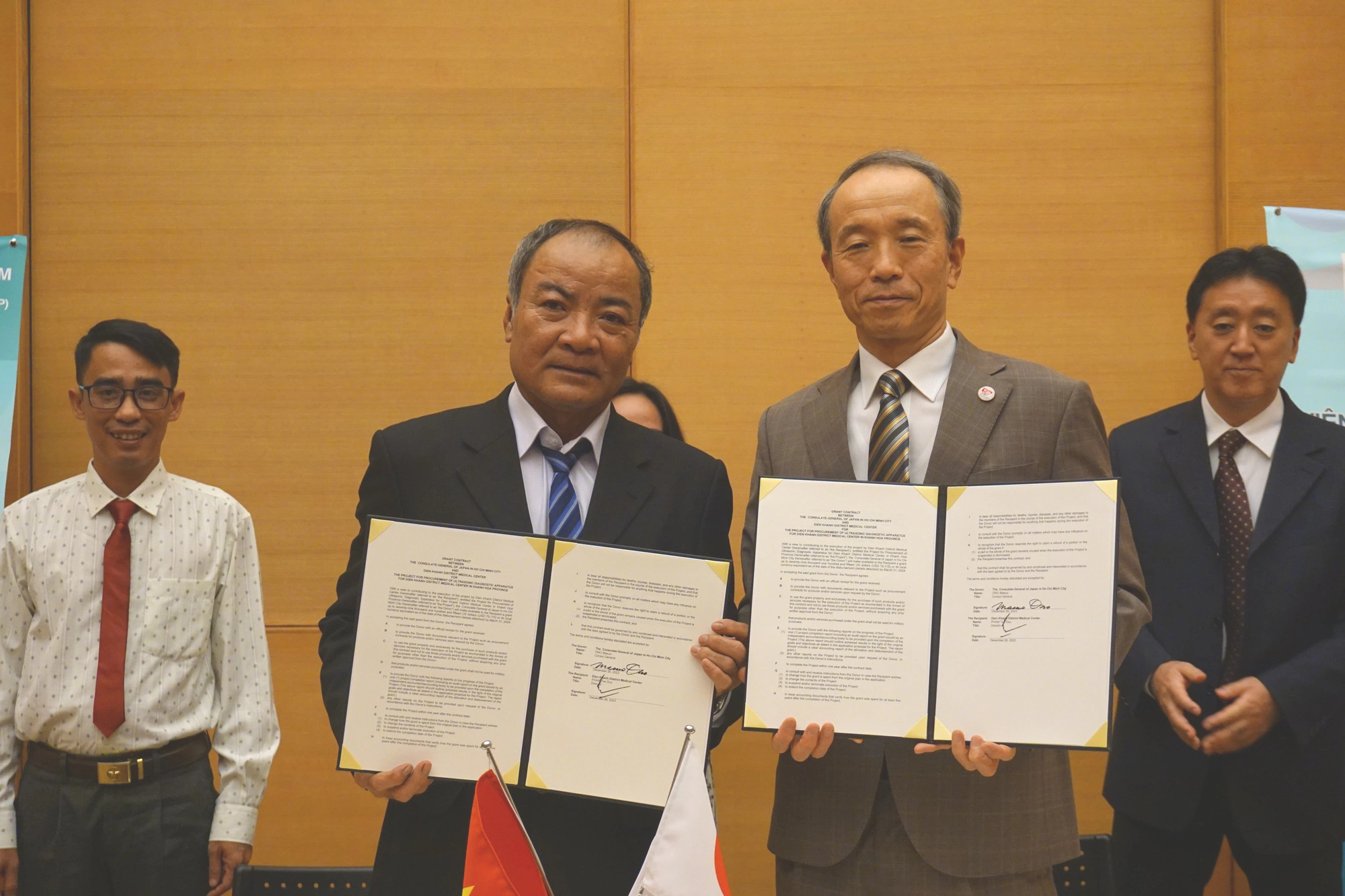 医療機器援助契約に署名した在ホーチミン日本国総領事の小野益雄氏（右）とディエンカン地区医療センター（カインホア市）のファム・タン・ドック所長 - 写真：NGHI VU