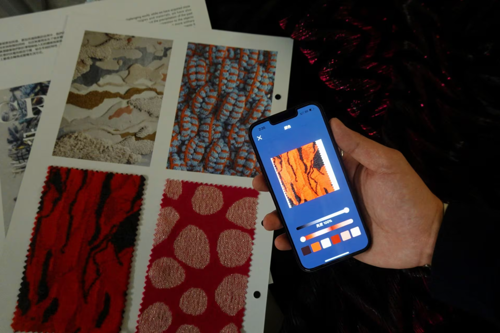 Một nhà nghiên cứu sử dụng tính năng cho phép người mặc trích xuất màu sắc từ ảnh trên điện thoại và "chiếu" chúng lên sợi vải - Ảnh: REUTERS
