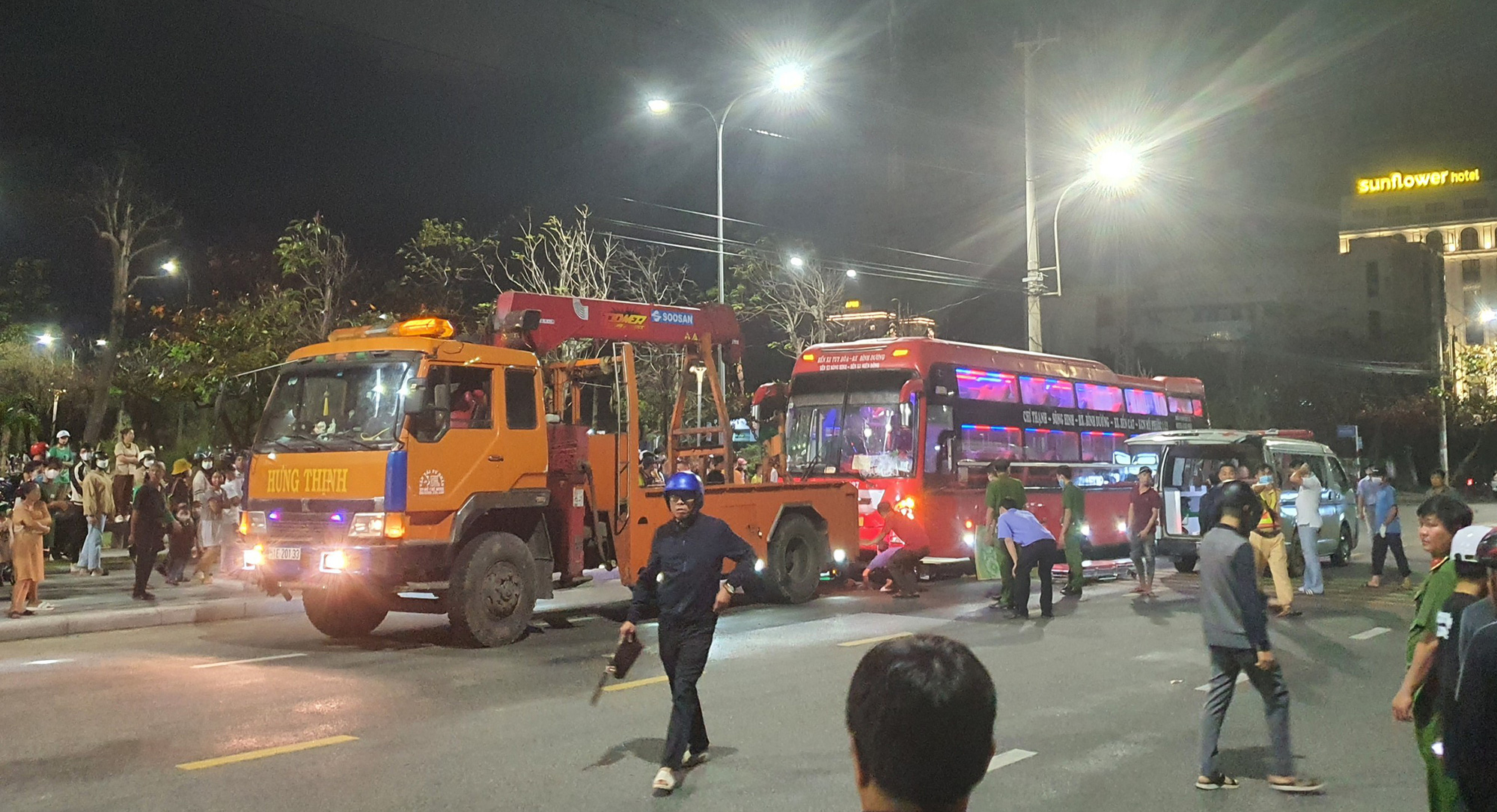 Xe cẩu được điều tới để cẩu nâng phần trước xe khách, đưa thi thể nam thanh niên ra ngoài - Ảnh: TRUNG TRẦN