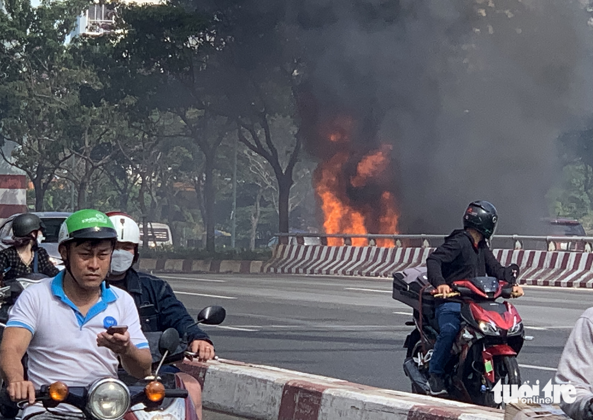 Đốt rác, lửa cháy cao lan qua cáp điện đường Phạm Văn Đồng - Ảnh 1.