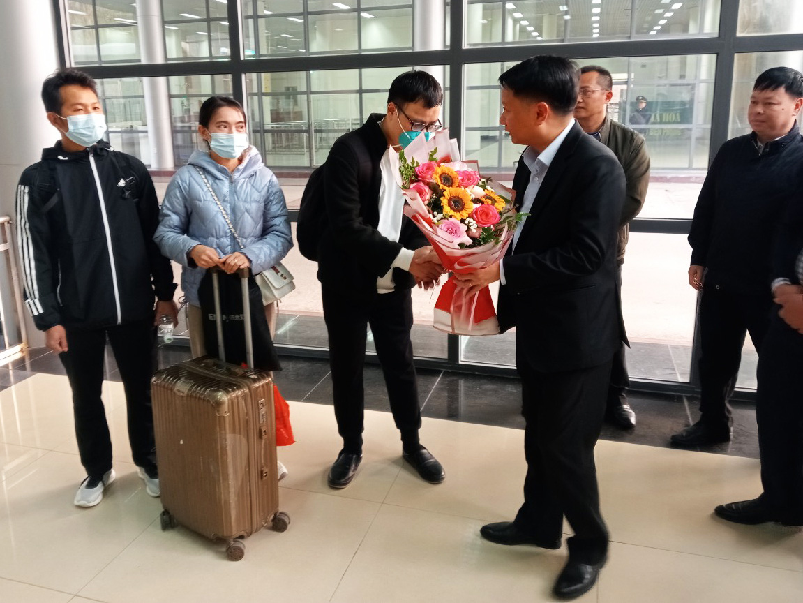 Lãnh đạo TP Móng Cái, tỉnh Quảng Ninh tặng hoa chào mừng những công dân từ Trung Quốc nhập cảnh vào Việt Nam trong sáng 21-2 - Ảnh: H. TÙNG