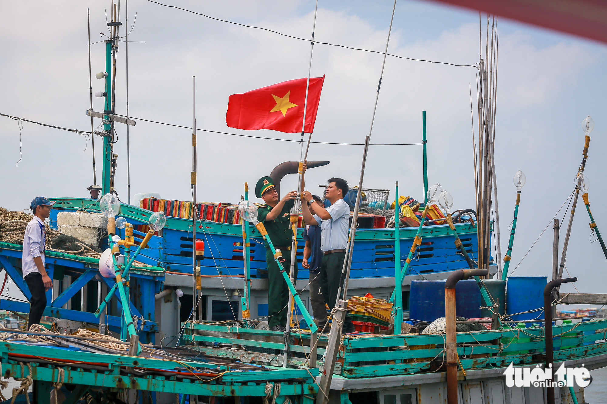 Các chiến sĩ Đồn biên phòng Sông Đốc (tỉnh Cà Mau) thay lá cờ tổ quốc mới cho ngư dân - Ảnh: CHÂU TUẤN