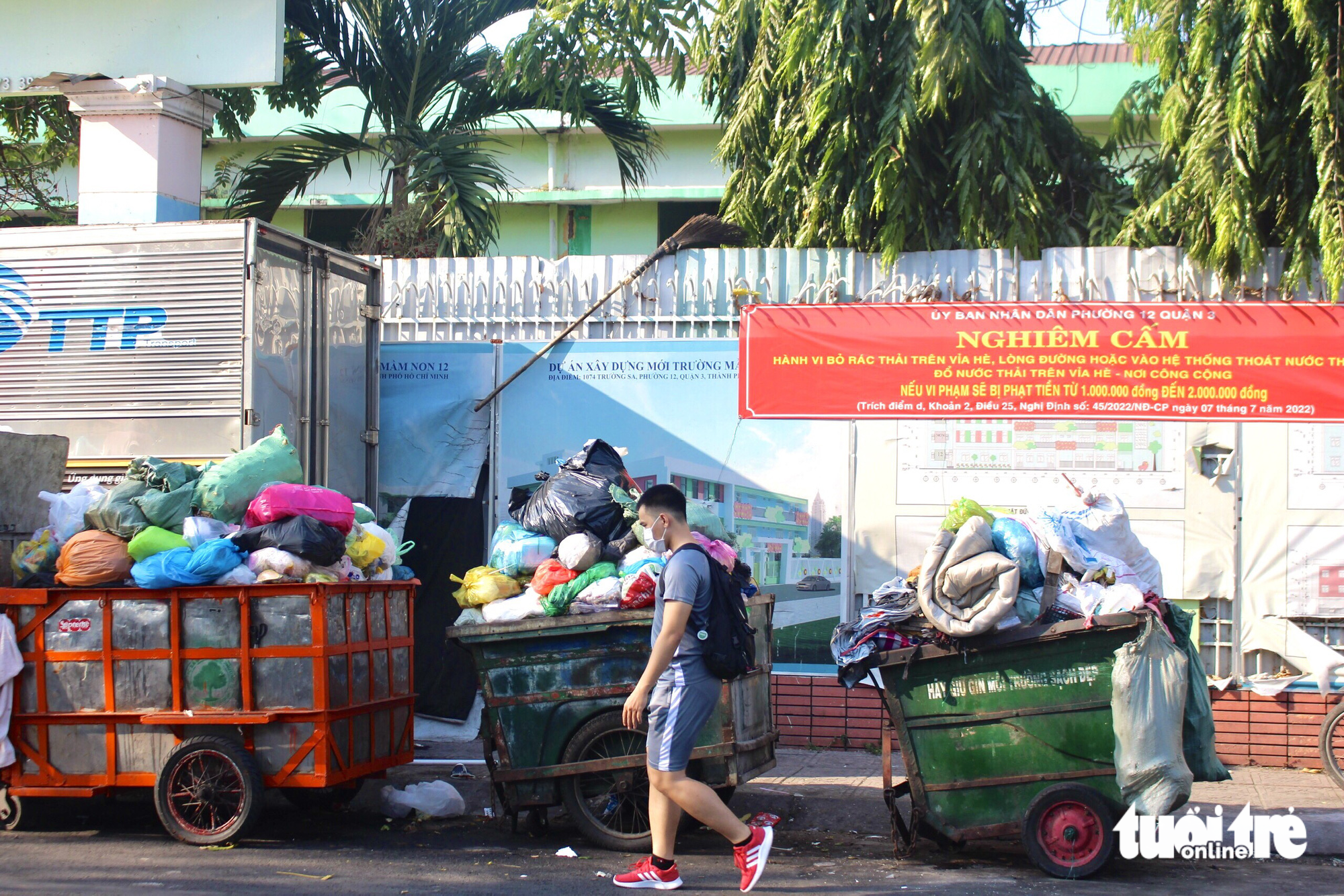 Các xe rác tập kết trải dài trên đường Trường Sa khiến người dân di chuyển qua đoạn đường này khó chịu bởi mùi hôi - Ảnh: LƯU DUYÊN
