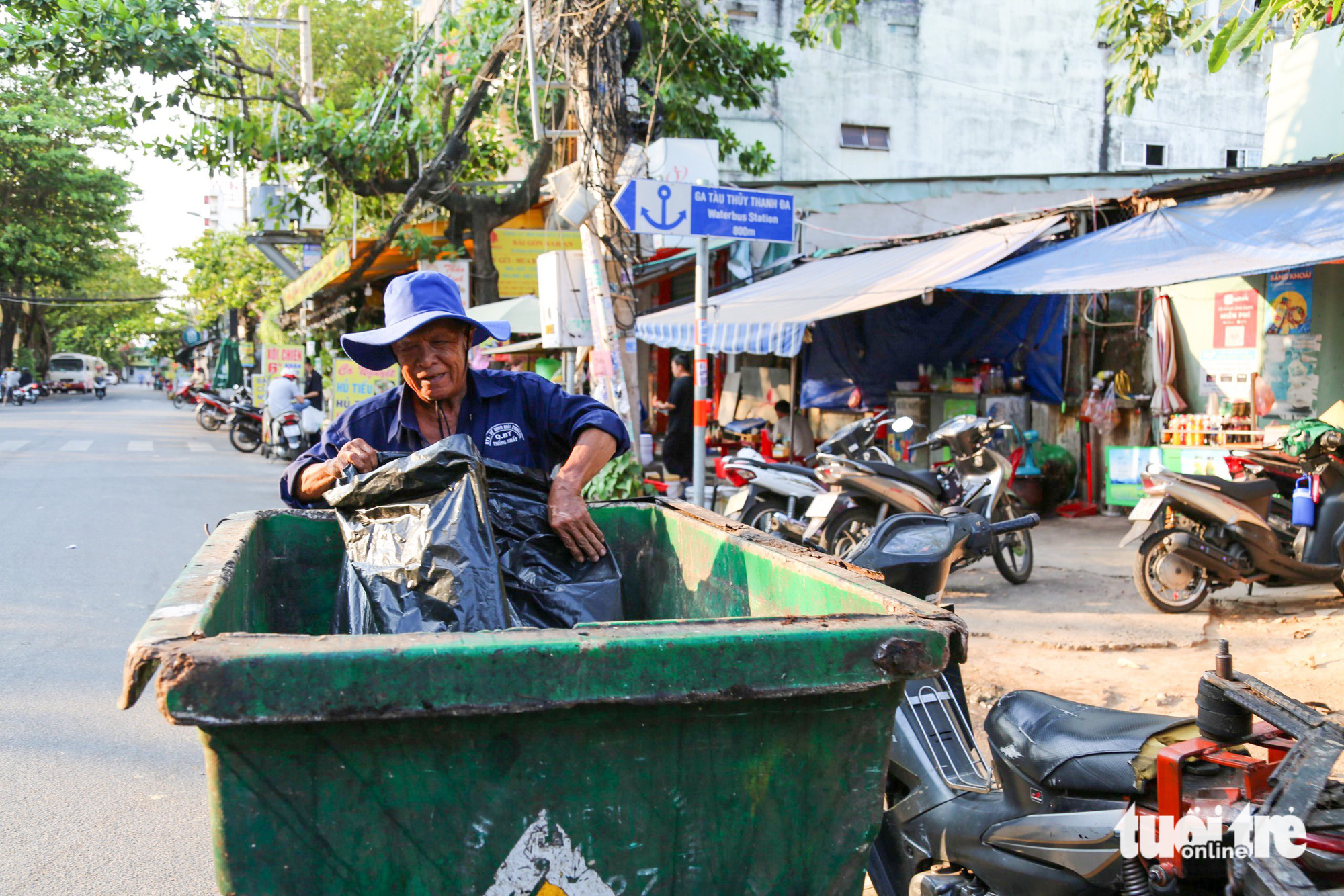 Công nhân thu rom và phân loại rác ở một bãi tự phát trên đường Thanh Đa (quận Bình Thạnh), xe thu gom rác này khá cũ kỹ và nhiều chỗ bị hư hỏng - Ảnh: PHƯƠNG QUYÊN