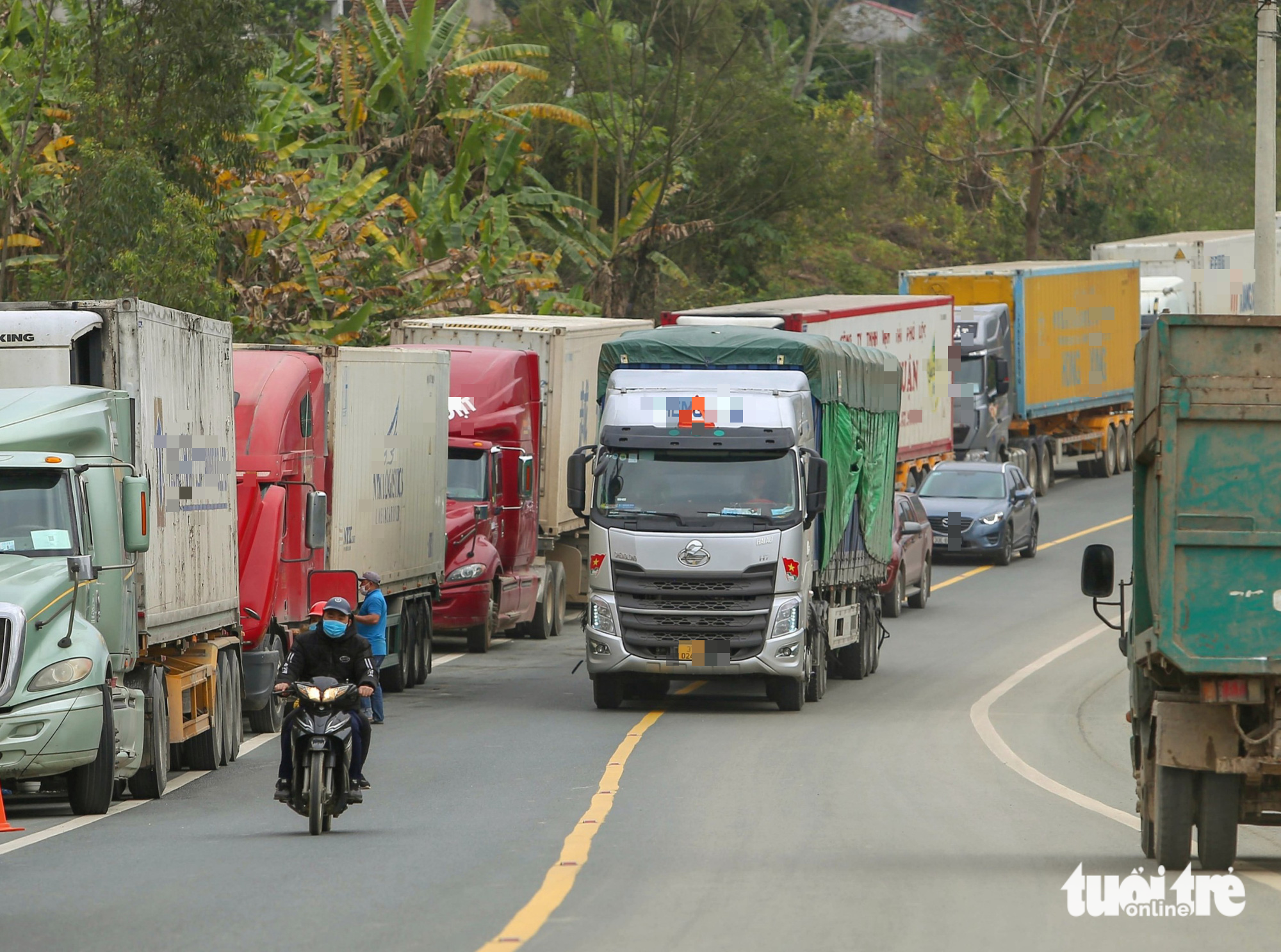 Container xếp hàng tràn quốc lộ, Trung Quốc làm thêm giờ để hỗ trợ thông quan - Ảnh 1.
