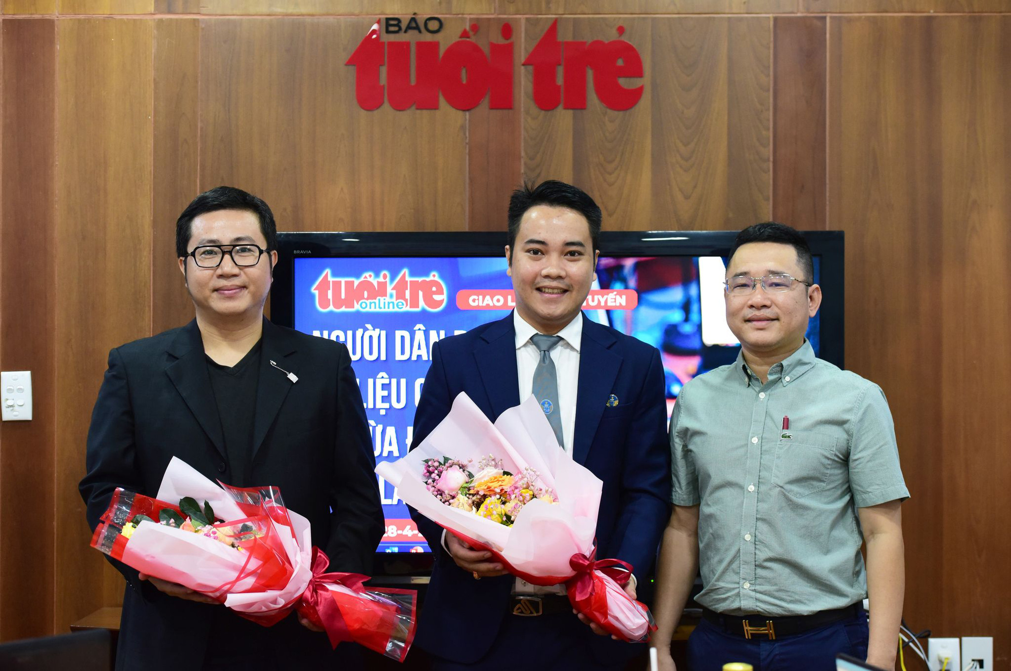 Ông Võ Minh Luận - thư ký tòa soạn báo Tuổi Trẻ (bìa phải) tặng hoa cho các khách mời - Ảnh: DUYÊN PHAN