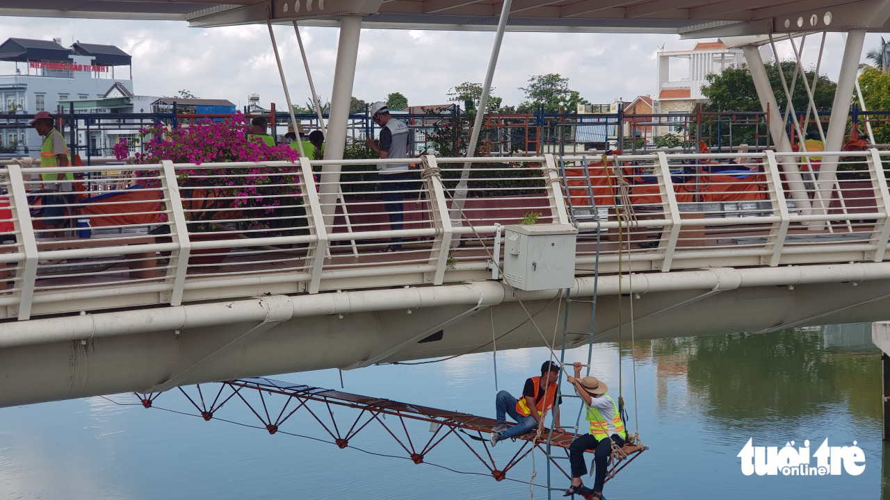 Các kỹ sư theo dõi các thiết bị lắp đặt dưới dạ cầu phục vụ công tác giám định - Ảnh: ĐẶNG TUYẾT