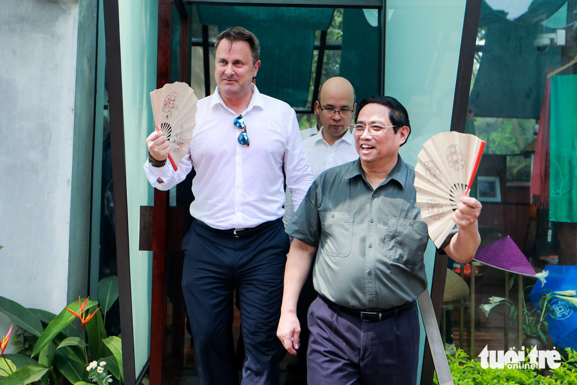 Do thời tiết Hà Nội ngày hôm nay khá oi bức nên hai thủ tướng đã mua chiếc quạt tại quầy lưu niệm tại Văn Miếu Quốc Tử Giám - Ảnh: NGUYỄN KHÁNH