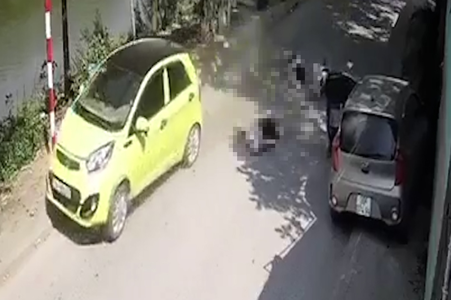 Hai người trên xe máy ngã ra đường và bị ô tô đi ngược chiều đâm trúng - Ảnh cắt từ clip