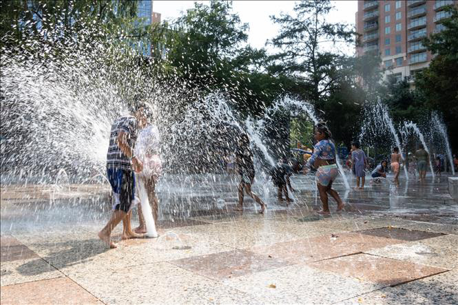 Trẻ em chơi đùa dưới vòi phun nước để tránh nóng tại Houston, Texas, Mỹ, ngày 15-6 - Ảnh: THX/TTXVN