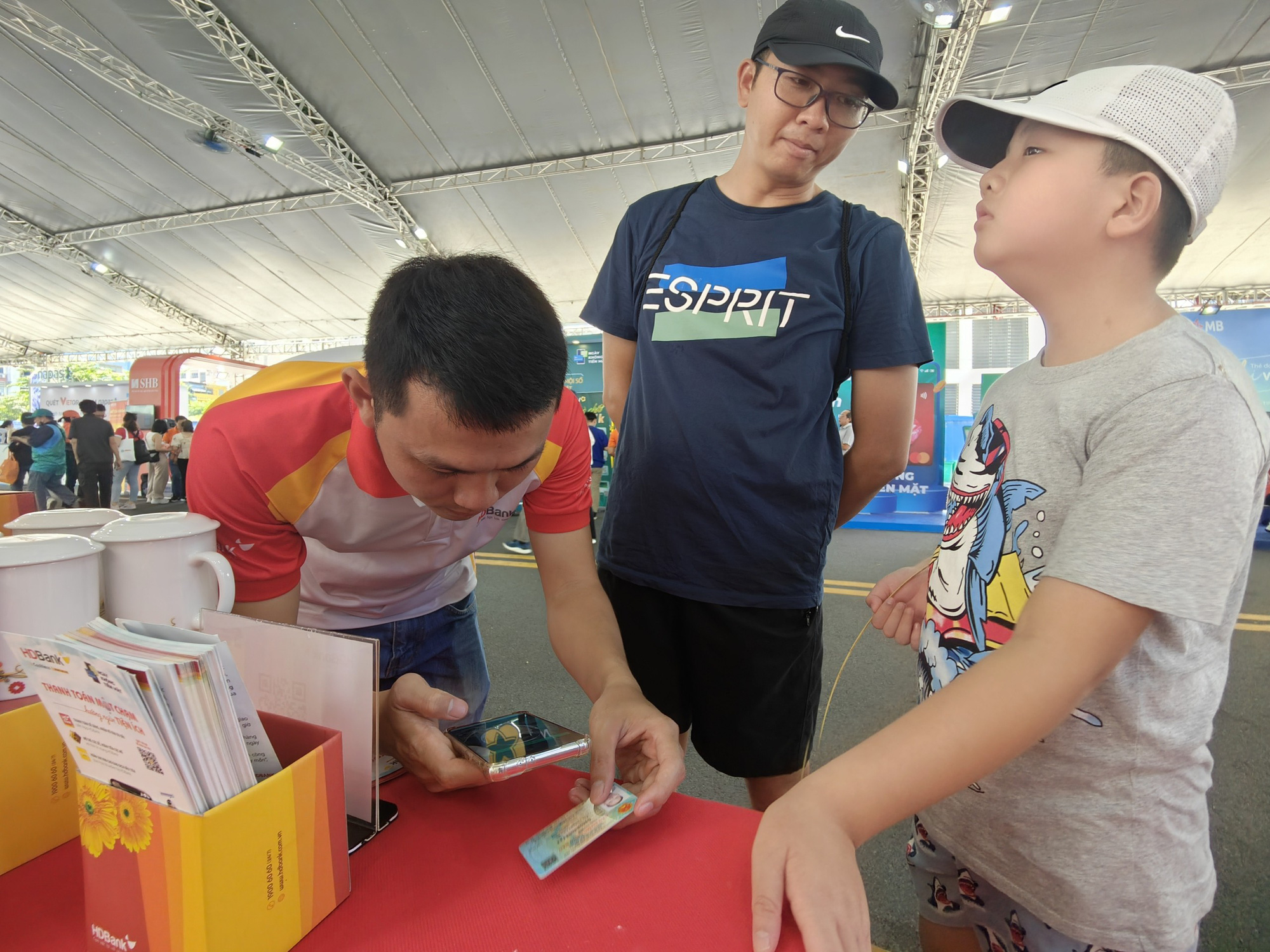 グエン・タイン・コンさんは11歳の息子を連れてキャッシュレス決済を体験する - 写真: DUC THIEN グエン・タイン・コンさんは11歳の息子を連れてキャッシュレス決済を体験させた - 写真: DUC THIEN