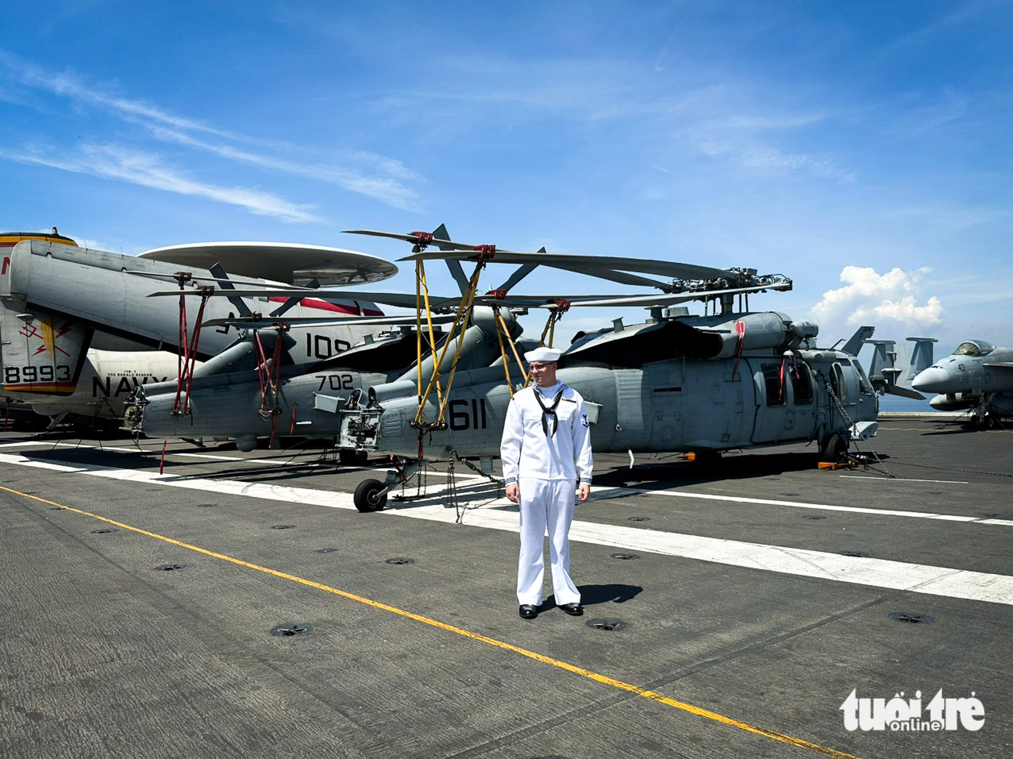 Quân nhân Mỹ bên cạnh các máy bay trực thăng xếp gọn trên boong tàu sân bay - Ảnh: T.L.