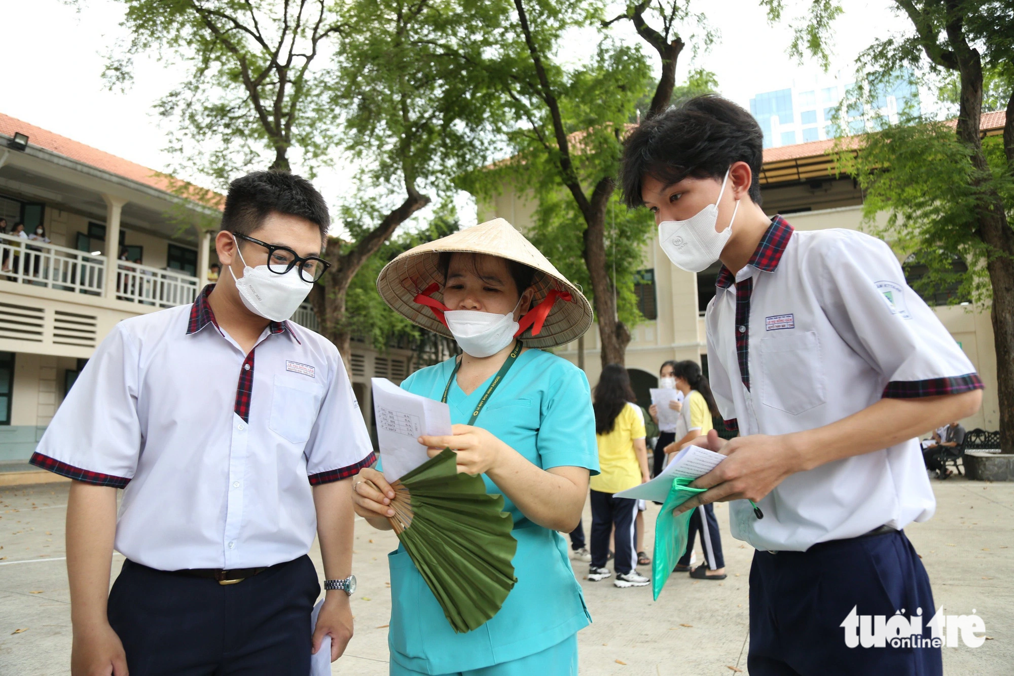 Cô Lê Thị Quý (Trường THPT Lê Quý Đôn) túc trực ở điểm thi để hướng dẫn sơ đồ phòng thi, nhắc nhở các em học sinh trước mỗi giờ thi - Ảnh: PHƯƠNG QUYÊN