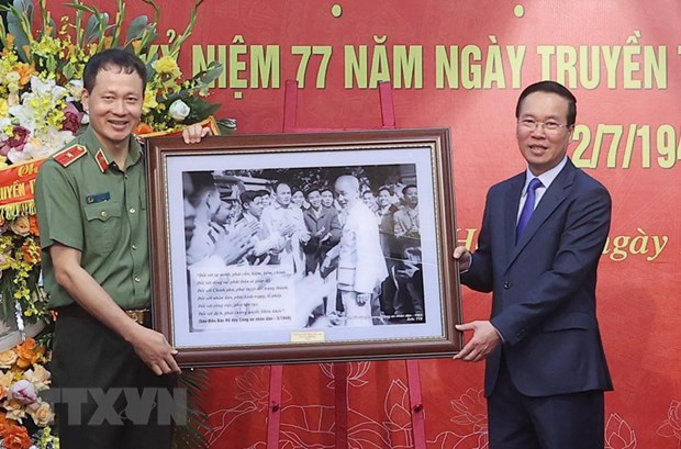 国内政治治安局の人民公安の役人や兵士たちとホーおじさんの写真を提示するボー・ヴァン・トゥオン大統領（写真：トン・ナット/VNA）