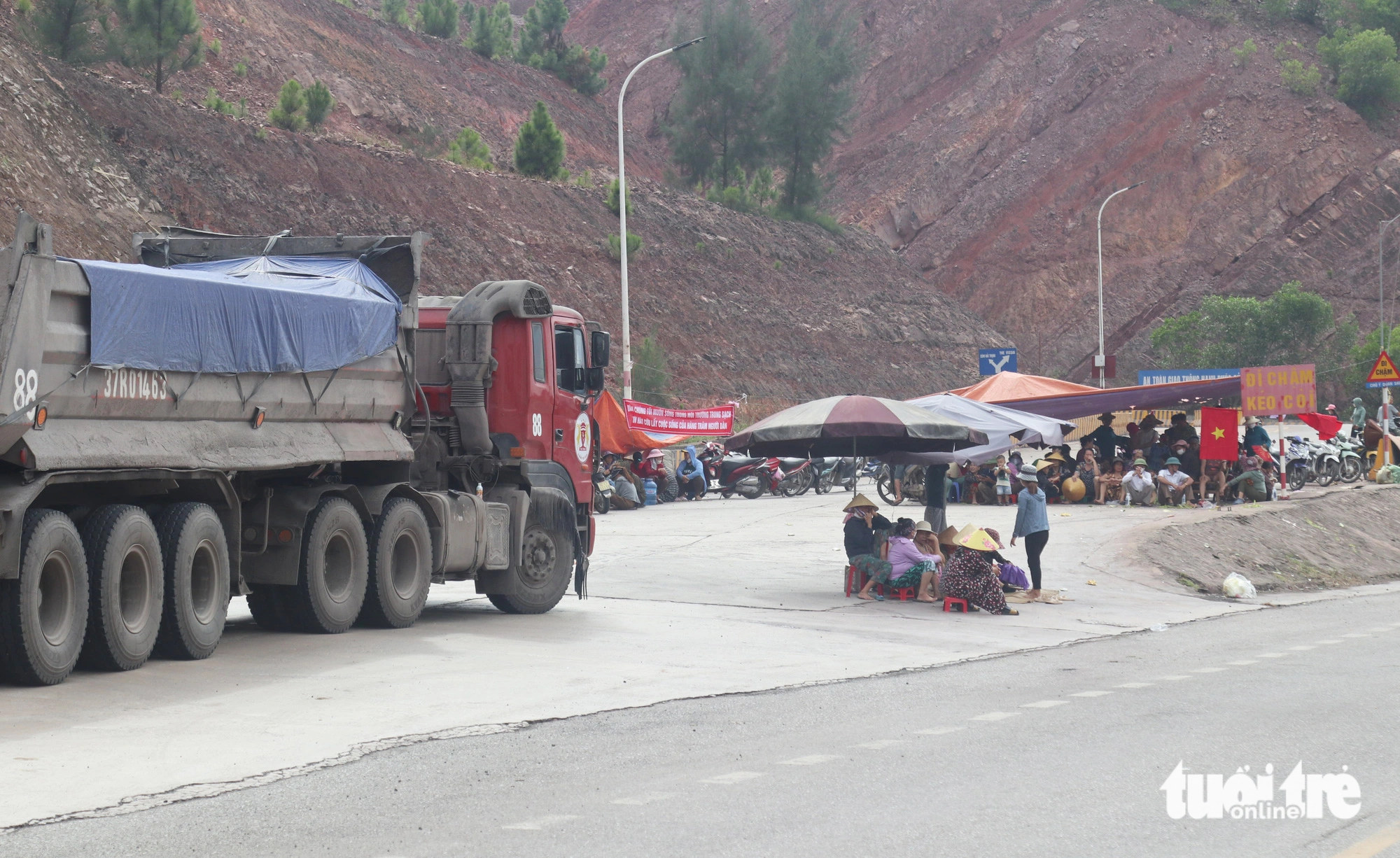Do người dân ngăn cản nên nhiều xe tải chở xi măng phải nằm dài trên đường - Ảnh: DOÃN HÒA