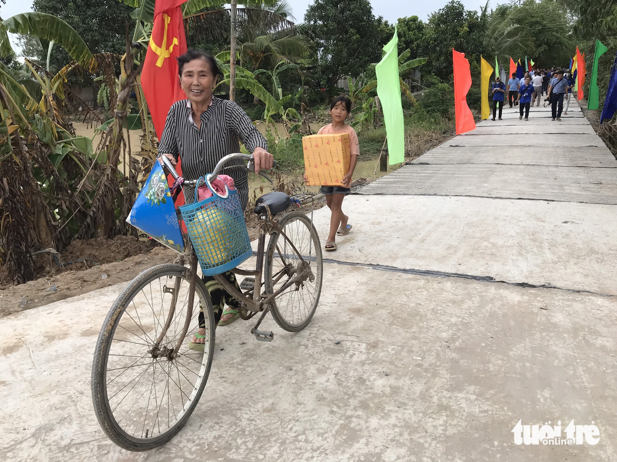 Niềm vui của bà cháu trên con đường nông thôn mới do chiến sĩ Mùa hè xanh TP.HCM thực hiện.