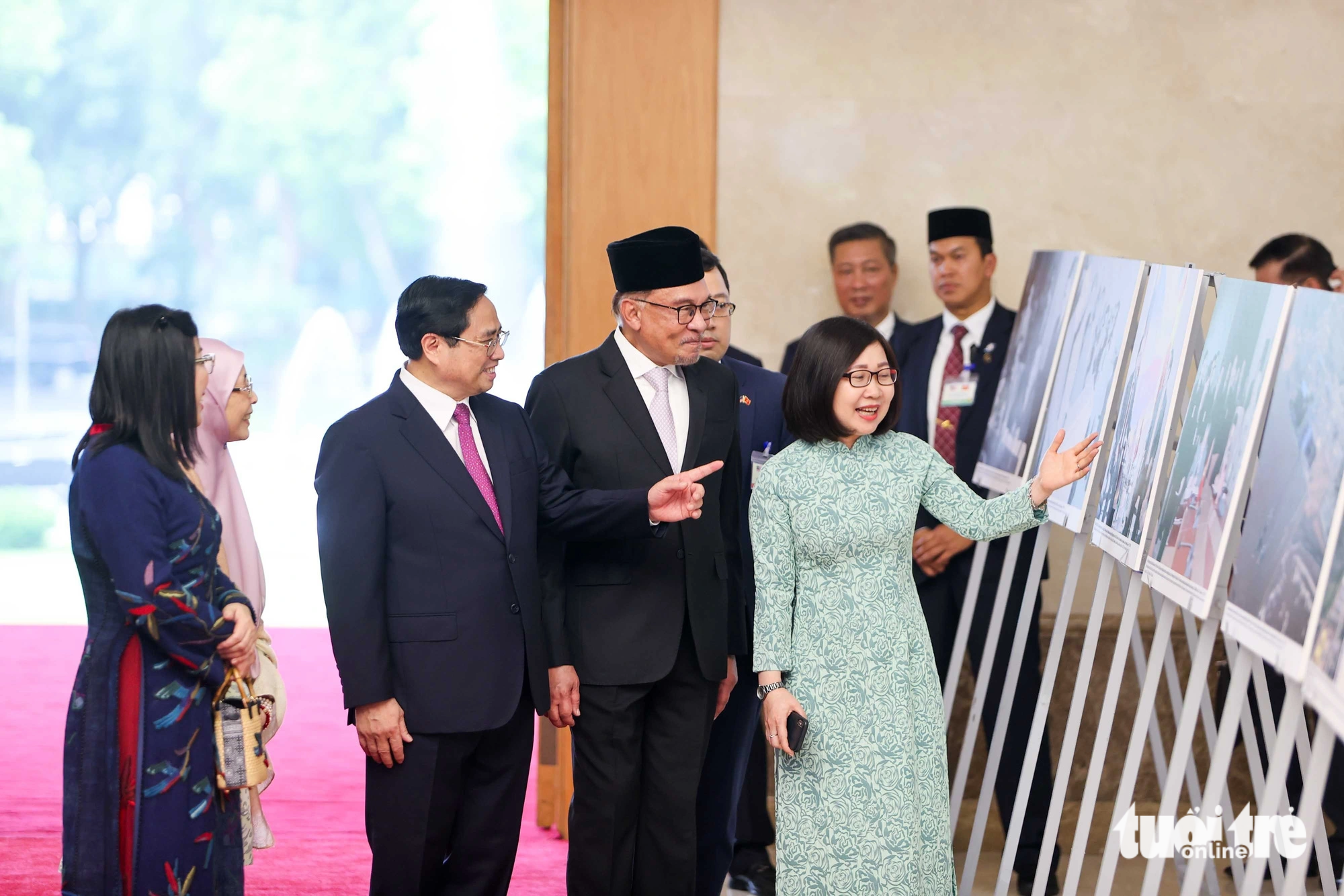Thủ tướng Phạm Minh Chính và Thủ tướng Malaysia Anwar Ibrahim cùng hai phu nhân xem triển lãm ảnh về quan hệ hai nước - Ảnh: NGUYỄN KHÁNH