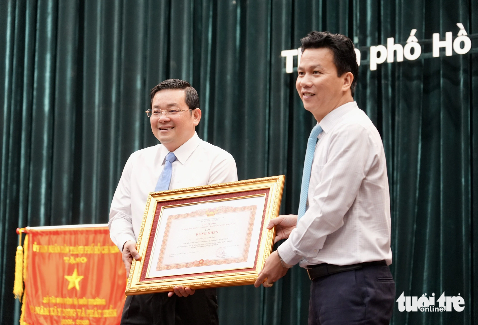 Bộ trưởng Bộ Tài nguyên và Môi trường Đặng Quốc Khánh (phải) trao bằng khen của Thủ tướng Chính phủ cho giám đốc Sở Tài nguyên và Môi trường TP.HCM Nguyễn Toàn Thắng - Ảnh: HỮU HẠNH