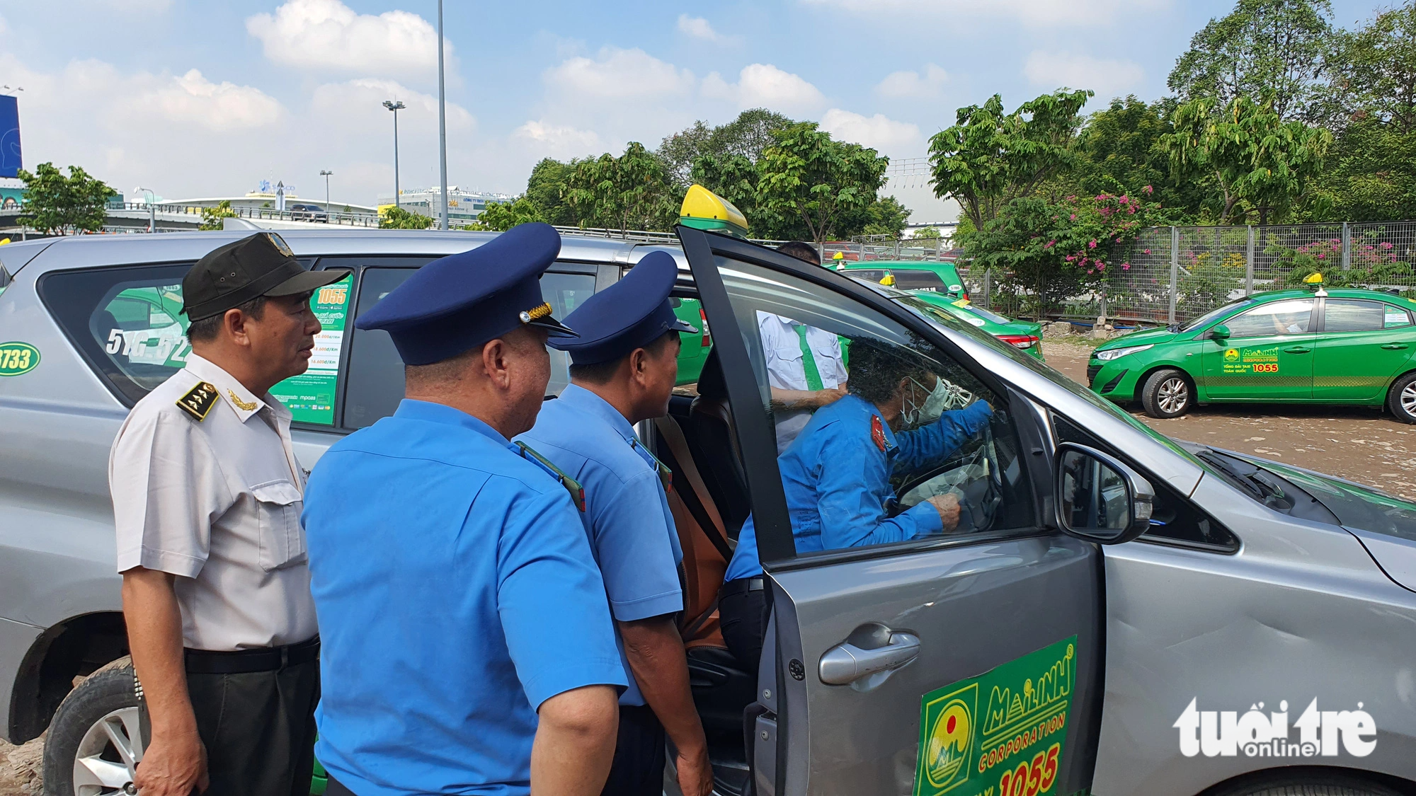 Lực lượng Thanh tra giao thông phối hợp An ninh sân bay kiểm tra taxi trong bãi đậu tạm - Ảnh: MINH HÒA
