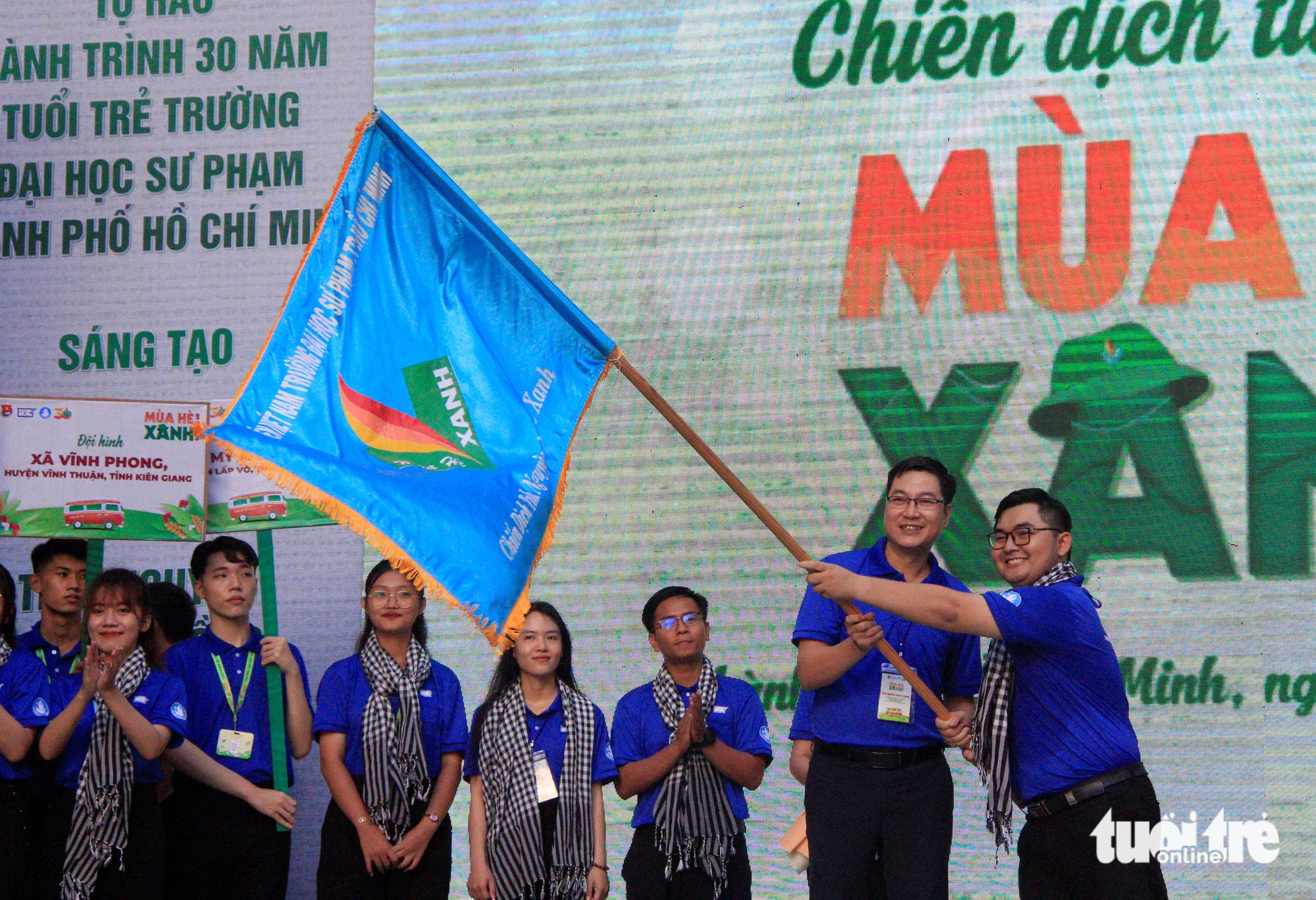 Phó hiệu trưởng Trường đại học Sư phạm TP.HCM Nguyễn Ngọc Trung trao cờ xuất quân Mùa hè xanh 2023 - Ảnh: CÔNG TRIỆU