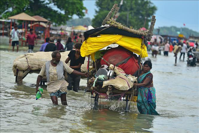 Người dân sơ tán khỏi vùng ngập lụt sau những trận mưa lớn tại Prayagraj, Ấn Độ, ngày 6-8 - Ảnh: AFP/TTXVN
