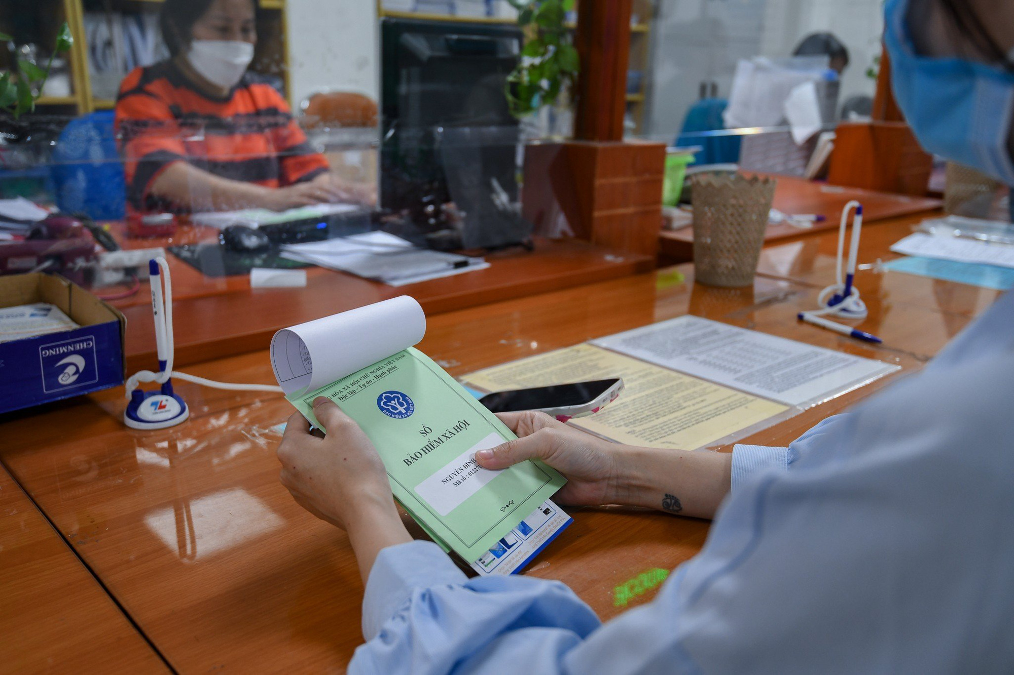 ハノイ市バーディン区で社会保険手続きを行う労働者 - 写真: NAM TRAN ハノイ市バーディン区で社会保険手続きを行う労働者 - 写真: NAM TRAN