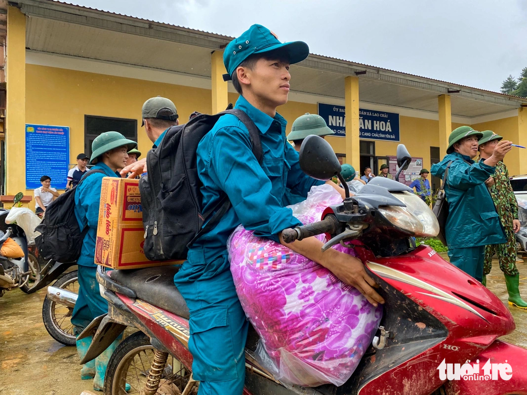 To quickly supply people in isolated areas in Mu Cang Chai, militia and self-defense forces used motorbikes to carry warm blankets and necessities such as instant noodles, bread, filtered water... - Photo: CHI tues