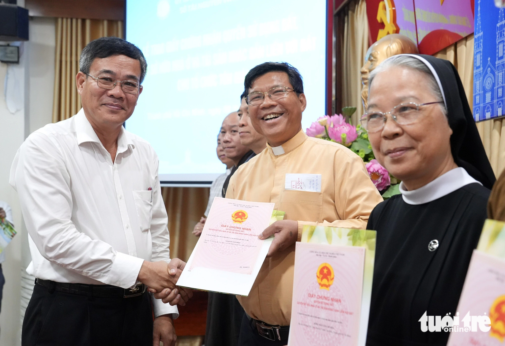 Ông Nguyễn Duy Tân, phó giám đốc Sở Nội vụ kiêm trưởng Ban Tôn giáo TP.HCM, trao "sổ hồng" cho các cơ sở tôn giáo - Ảnh: HỮU HẠNH