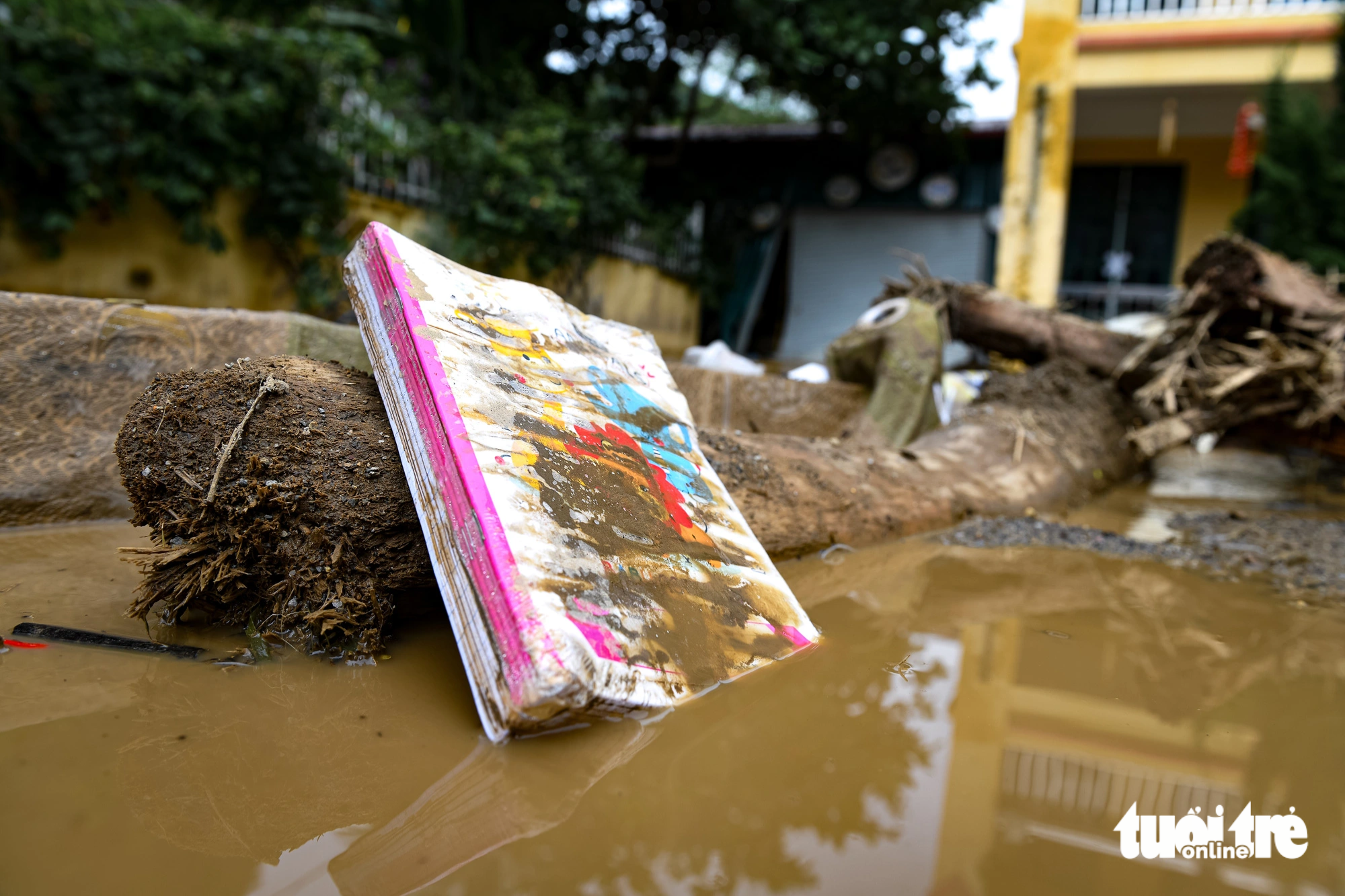 Sách vở của học sinh đã bị cuốn trôi hoặc bị bùn đất vùi lấp - Ảnh: NAM TRẦN