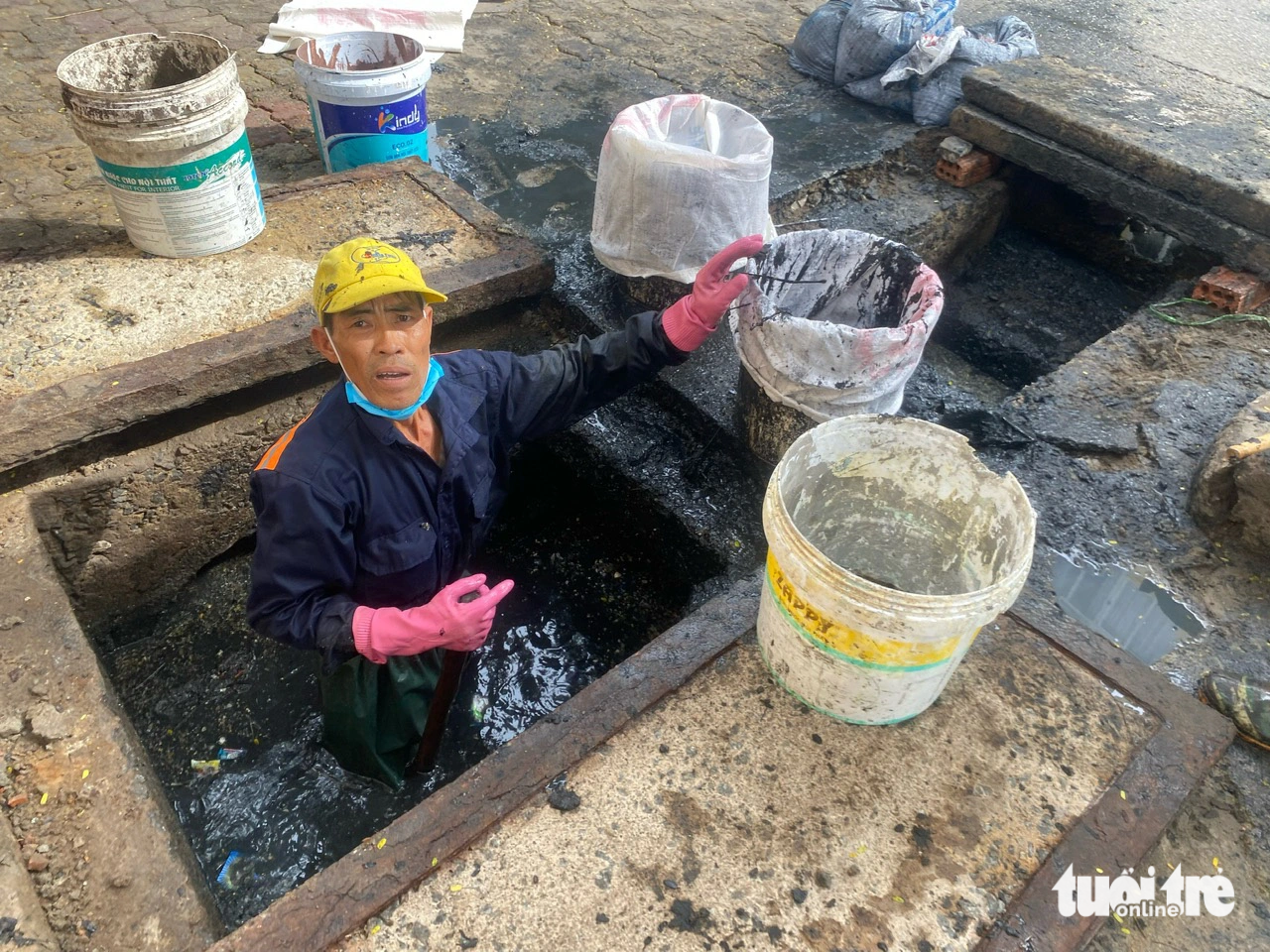 Thu bùn non từ một hố ga trên tuyến đường chính ở quận Hải Châu, Đà Nẵng - Ảnh: TRƯỜNG TRUNG