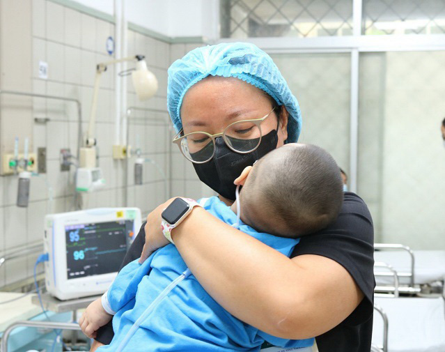 Cán bộ y tế Bệnh viện Bạch Mai chăm sóc trẻ là nạn nhân trong vụ cháy chung cư mini - Ảnh: BVCC