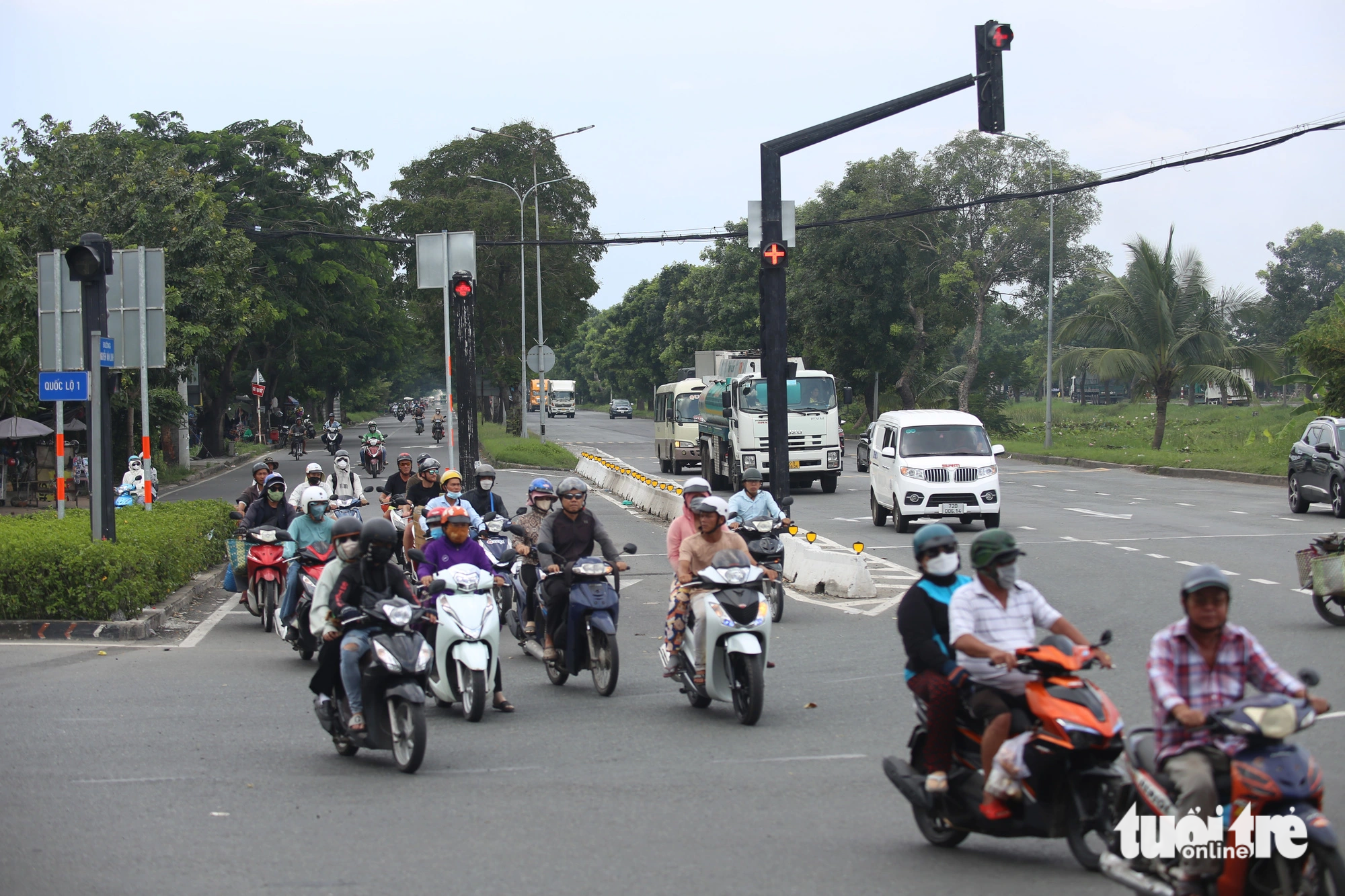 Xe lớn từ đường Nguyễn Văn Linh dừng đèn đỏ, để xe máy đi thẳng khi đèn xanh, không còn xung đột hướng như trước - Ảnh: MINH HÒA