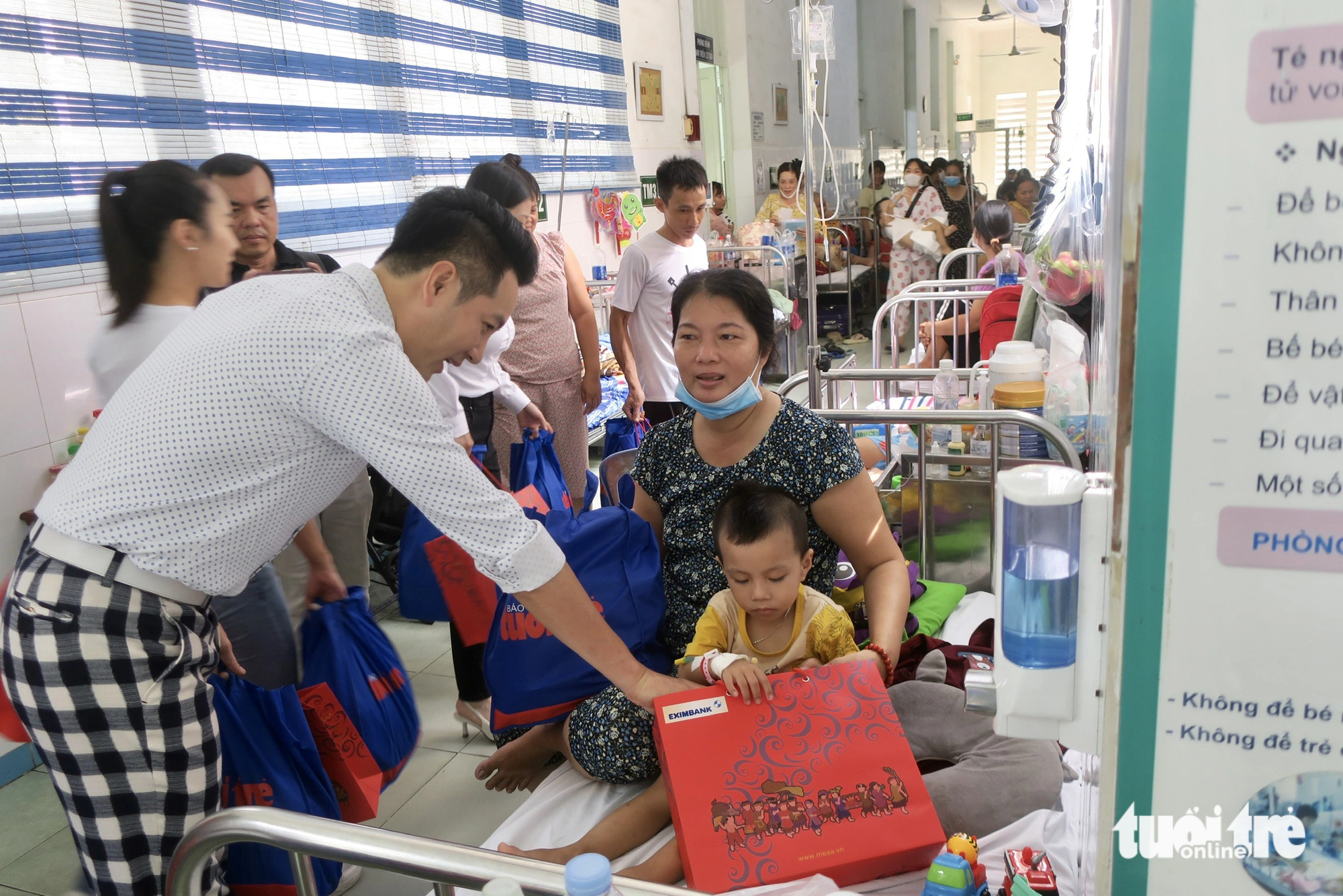 Nguyễn Phi Hùng trao quà và thăm hỏi bé Nguyễn Thành Nhân (3 tuổi) đang điều trị bệnh xuất huyết não - Ảnh: T.T.D.