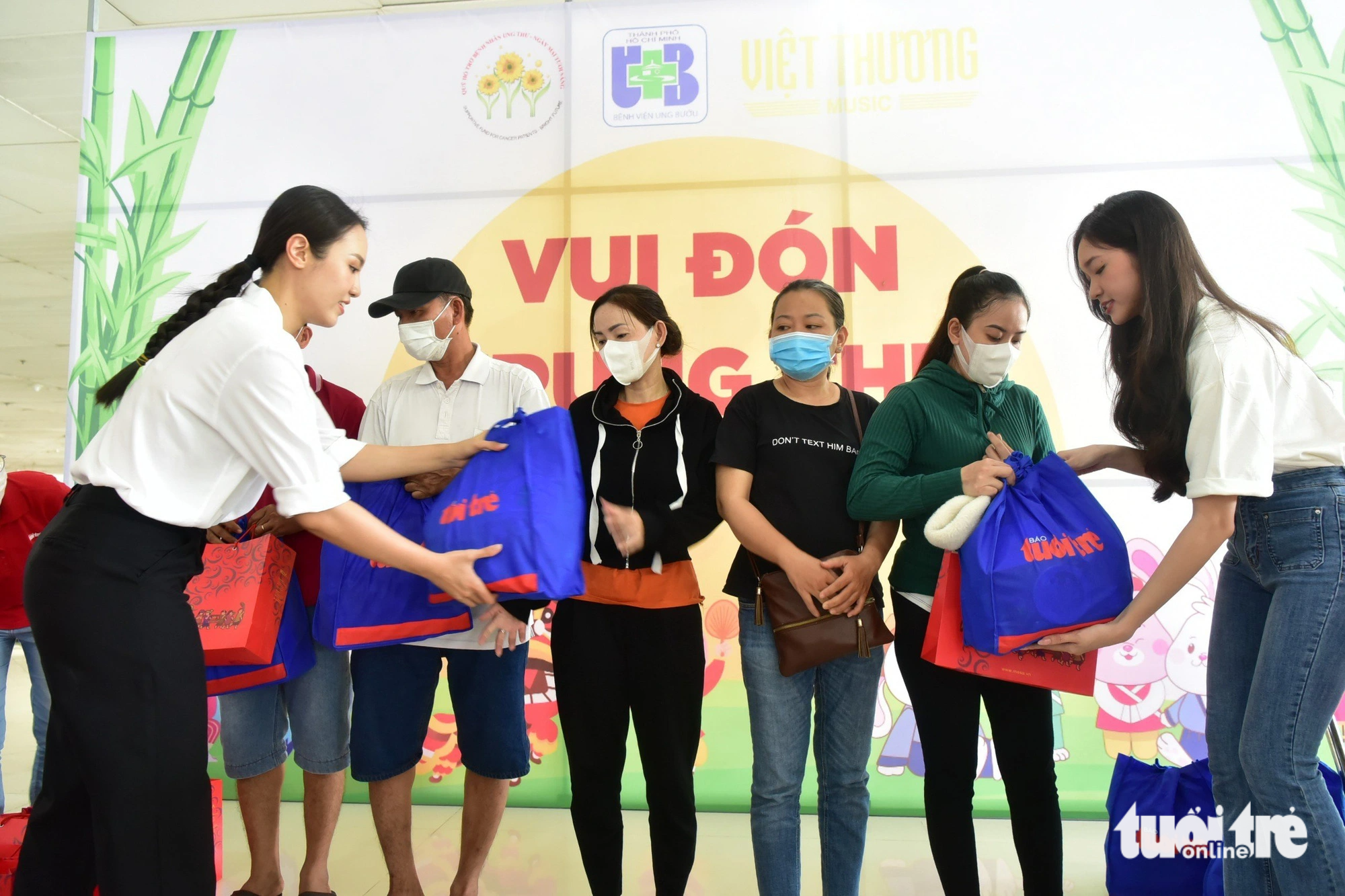 Runner-up Thuy Tien (left cover) and Miss Kim Ngan (right cover) give gifts to pediatric patients - Photo: TTD
