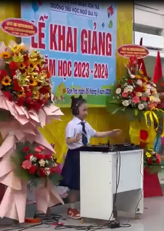 Một học sinh nữ làm DJ trên sân khấu lễ khai giảng - Ảnh cắt từ clip