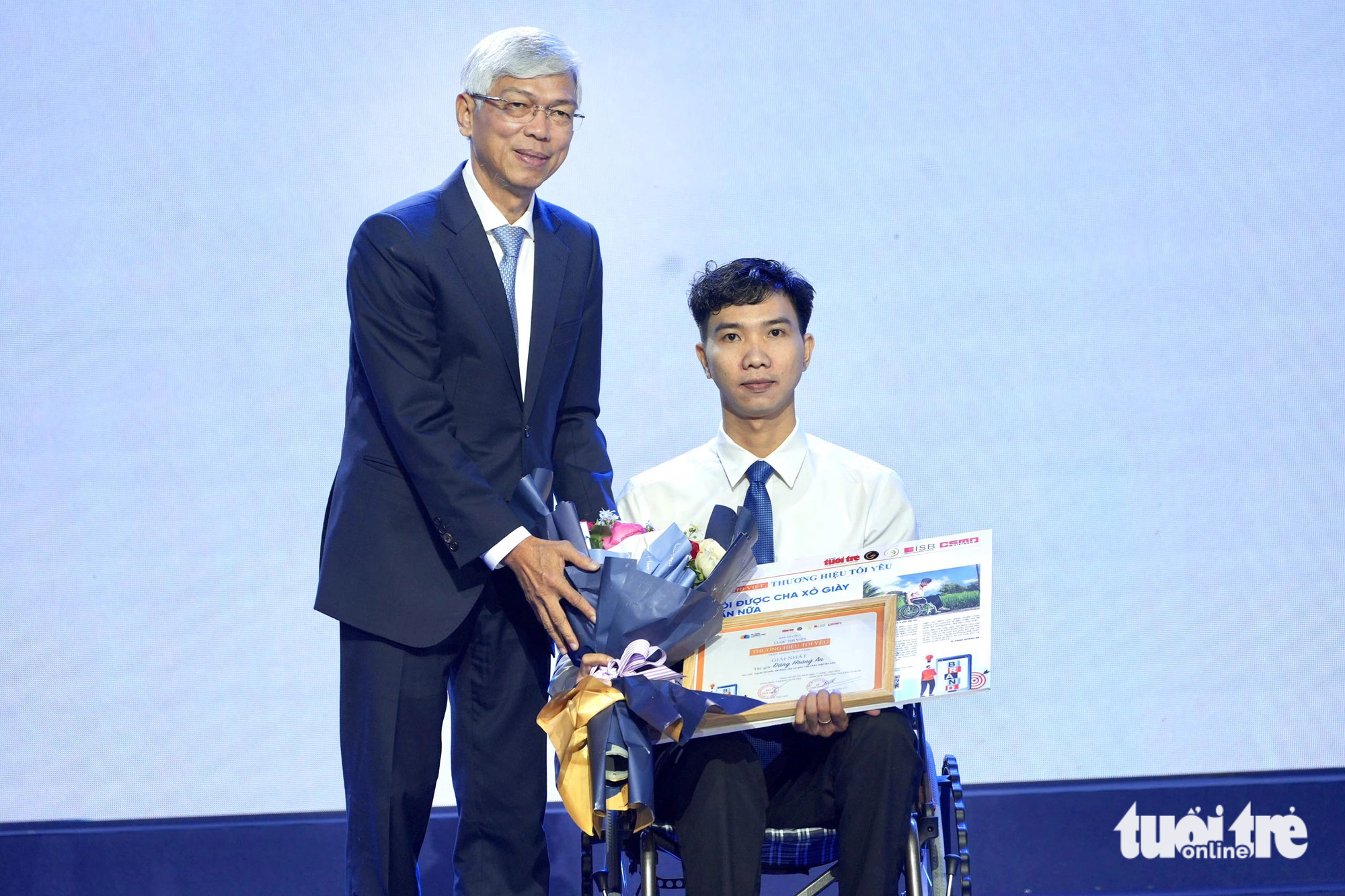 Phó chủ tịch UBND TP.HCM Võ Văn Hoan trao giải nhất cuộc thi “Thương hiệu tôi yêu” cho tác giả Đặng Hoàng An với bài “Ngoài 30 tuổi, tôi được cha xỏ giày vào chân một lần nữa” - Ảnh: HỮU HẠNH