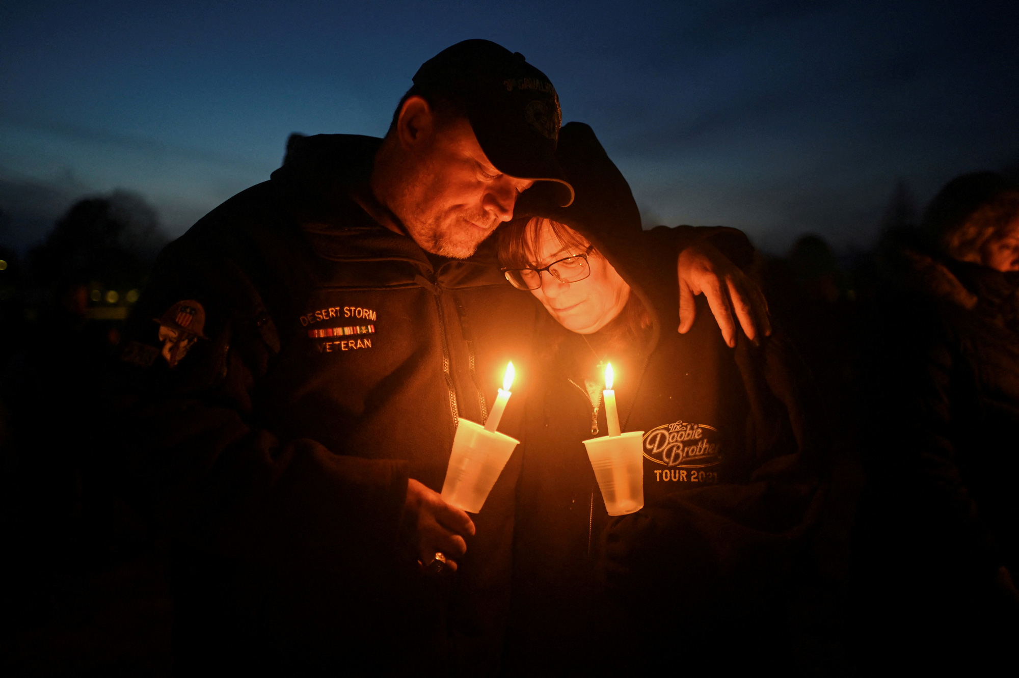 米国アイオワ州ペリー市のペリー高校での銃乱射事件後の祈祷会で抱き合うダン夫妻とキャシー・プラット氏、1月4日 - 写真: REUTERS