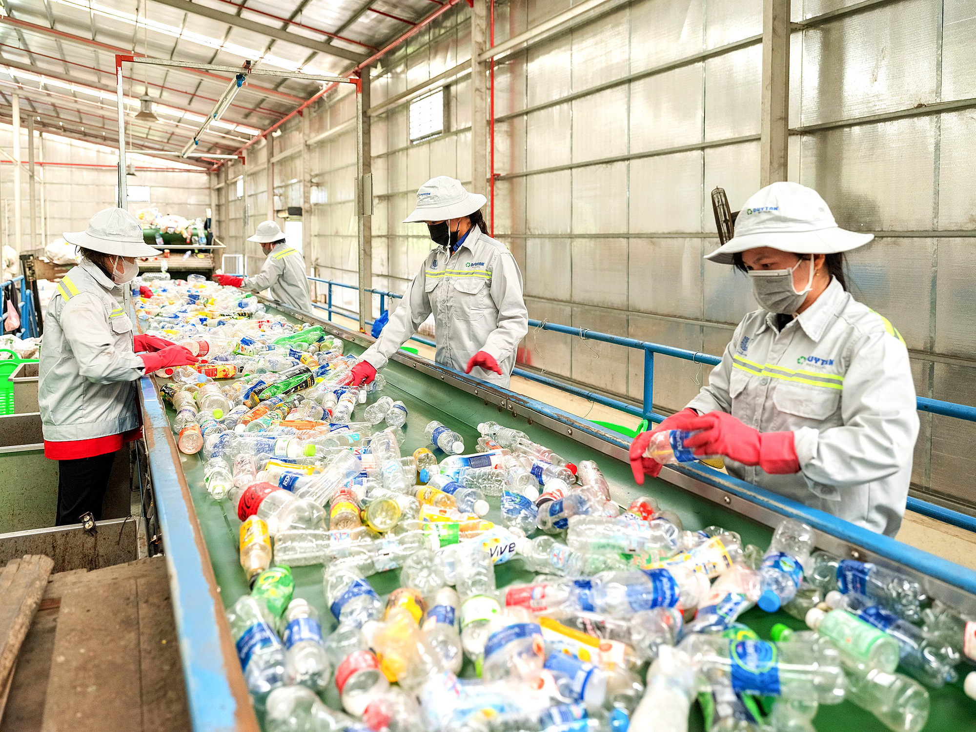 Công nhân kiểm tra và phân loại chai nhựa thải bỏ sau tiêu dùng - Ảnh: PHI VÂN