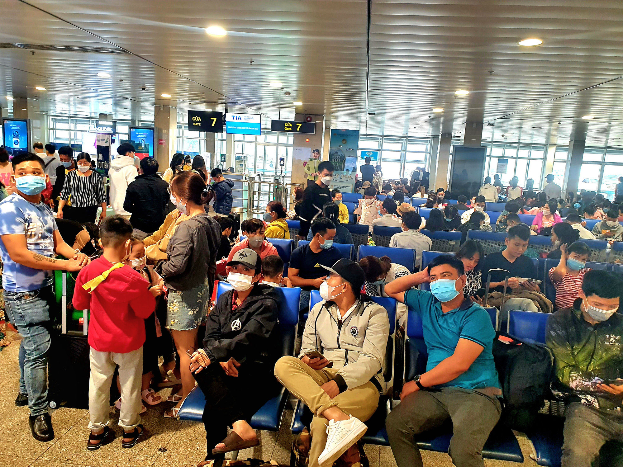 Passageiros aguardam a partida do voo na saída do Aeroporto Internacional Tan Son Nhat - Foto: CONG TRUNG Khách ngồi chờ chuyến bay khởi hành tại lối ra cửa máy bay cảng hàng không quốc tế Tân Sơn Nhất, khi có thêm sân bay sẽ giảm tải cho sân bay hiện có tại TP.HCM - Ảnh: CÔNG TRUNG